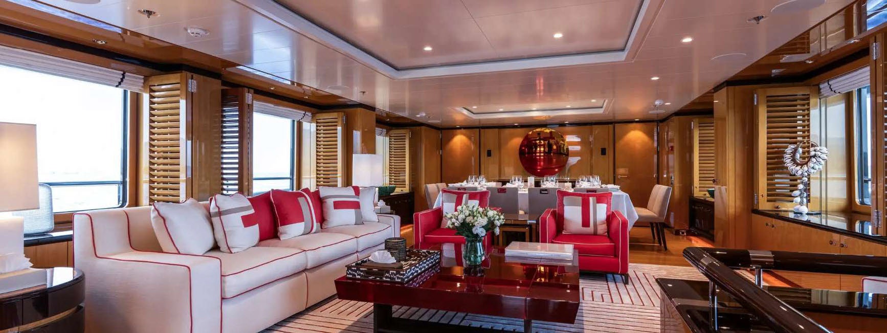 a living room with a red couch and a table aboard DEEP BLUE Yacht for Charter