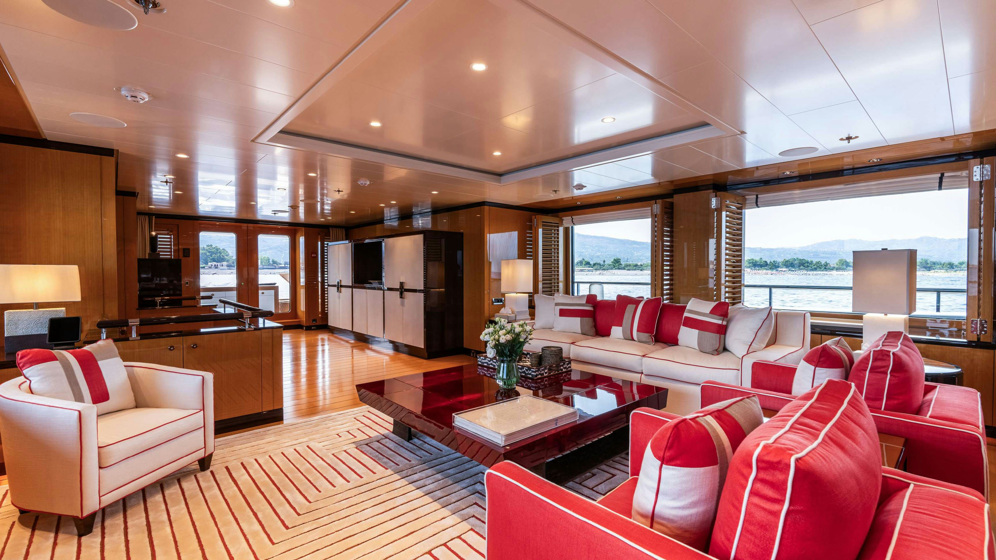 a living room with red couches aboard DEEP BLUE Yacht for Charter