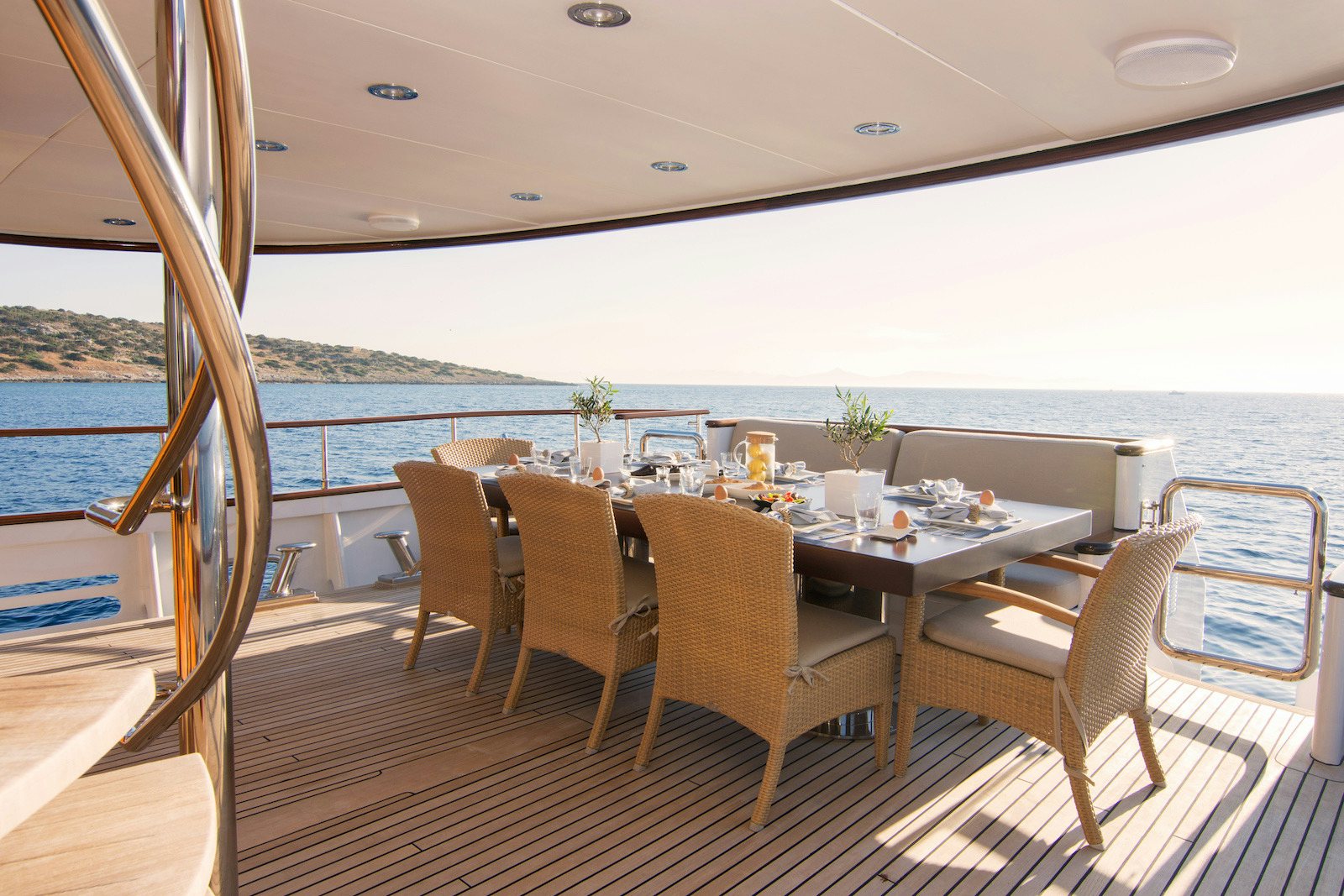 a table set for a meal on a deck overlooking the ocean aboard PARVATI Yacht for Sale