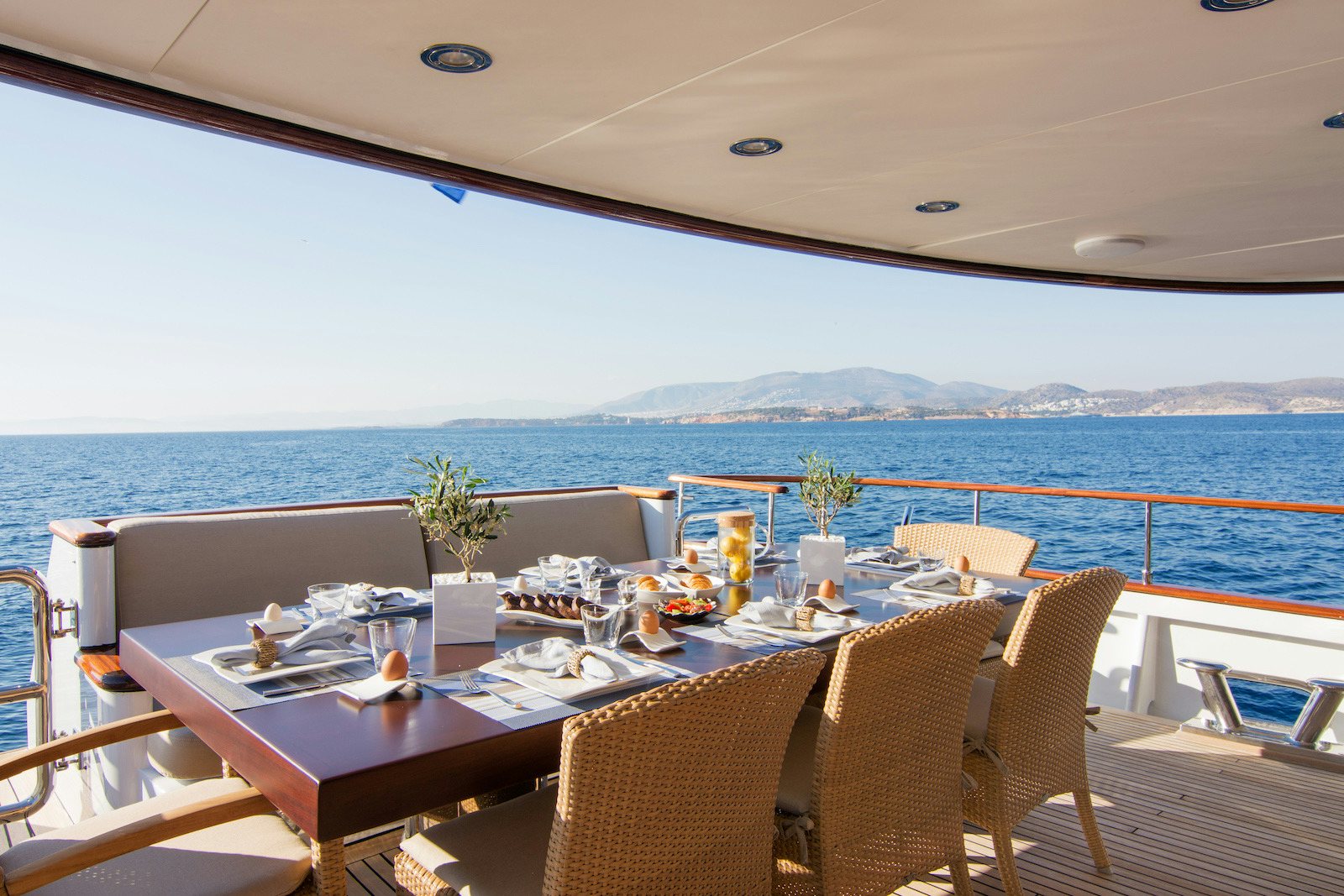 a table set for a meal on a balcony overlooking the ocean aboard PARVATI Yacht for Sale