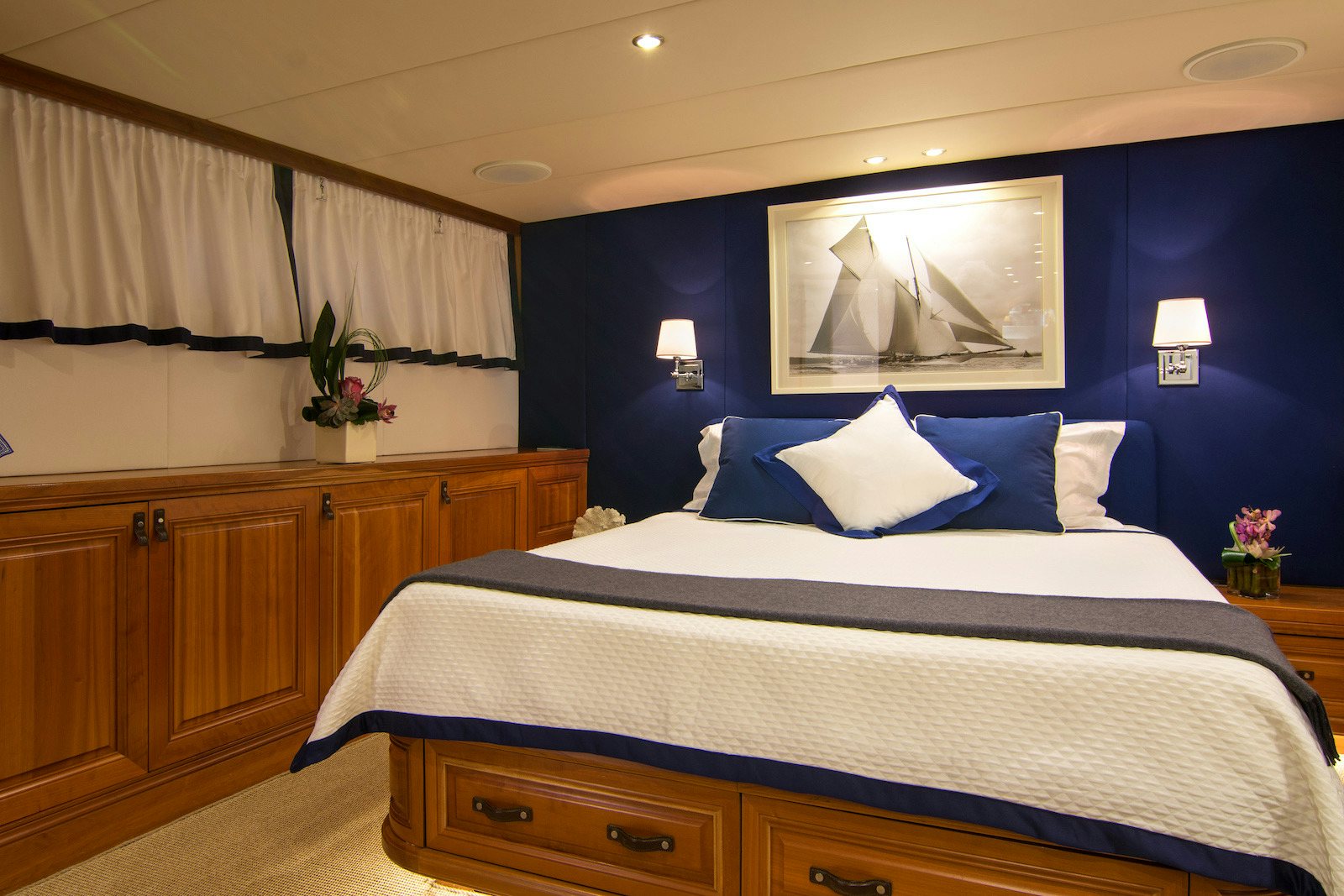 a bed with a blue wall aboard PARVATI Yacht for Sale