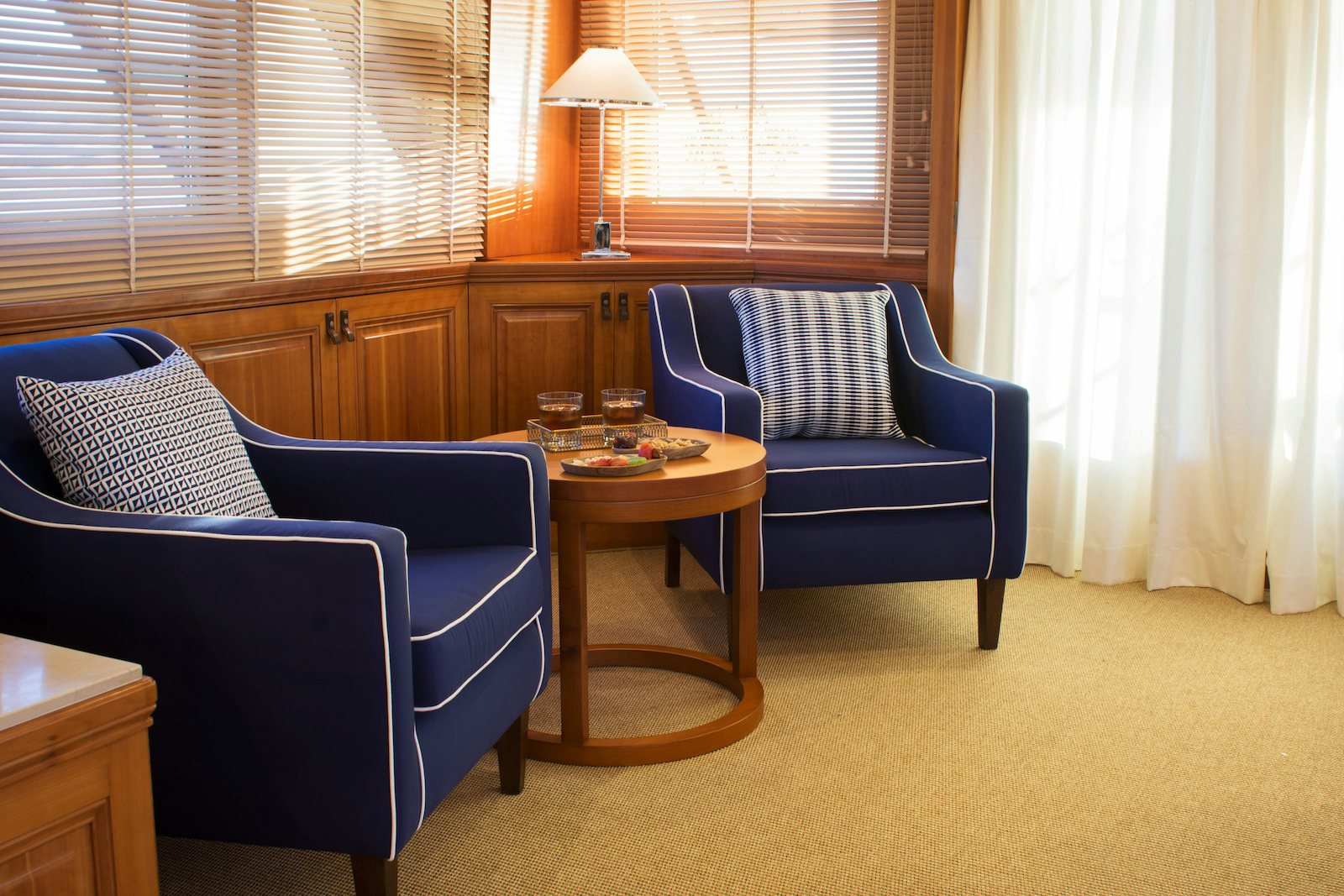 a living room with a blue chair aboard PARVATI Yacht for Sale