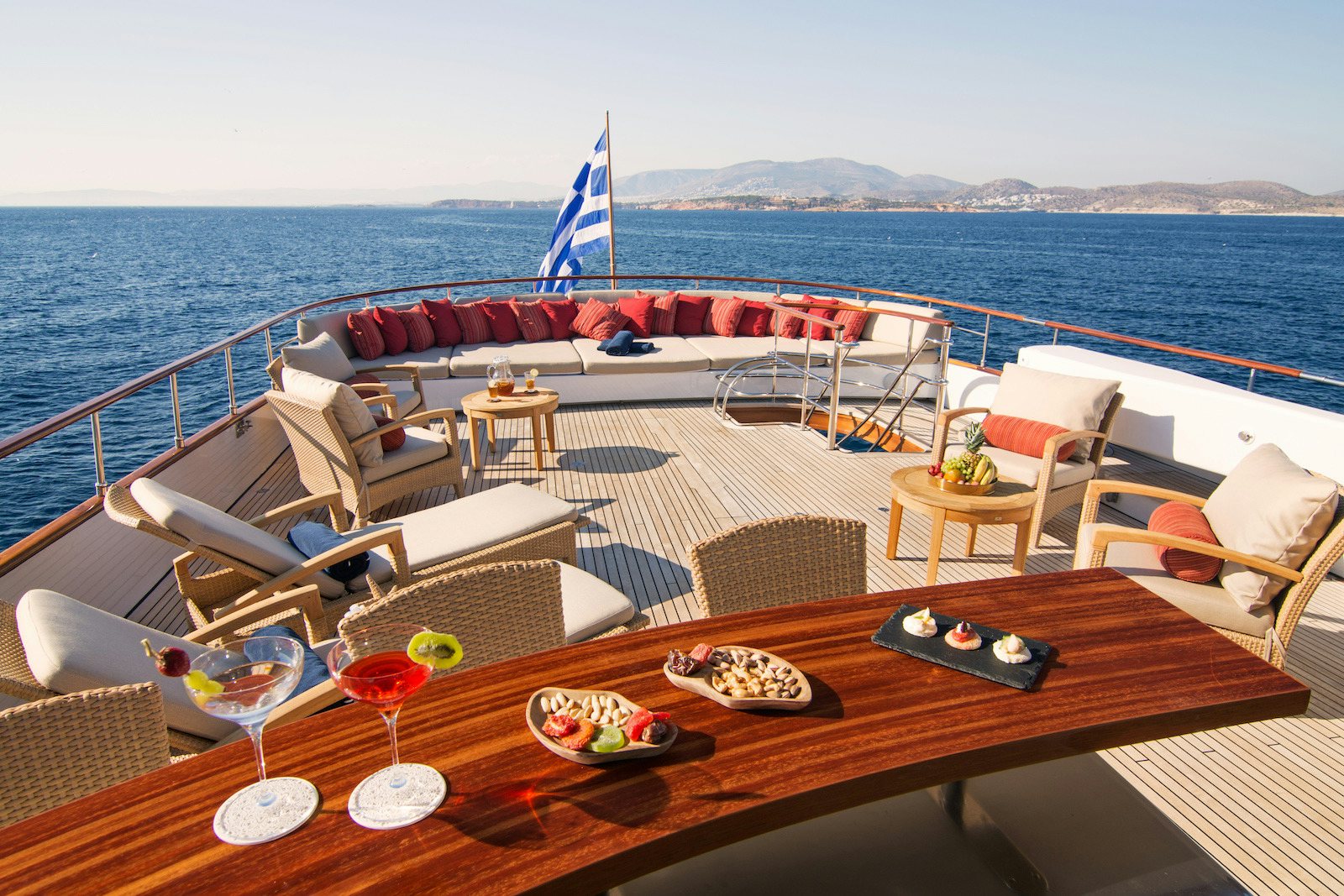 a table with chairs and a table on it by the water aboard PARVATI Yacht for Sale