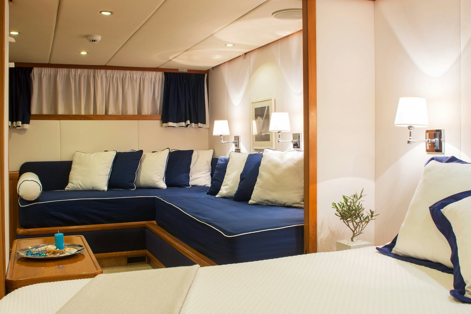 a bedroom with a blue bed and white sheets aboard PARVATI Yacht for Sale