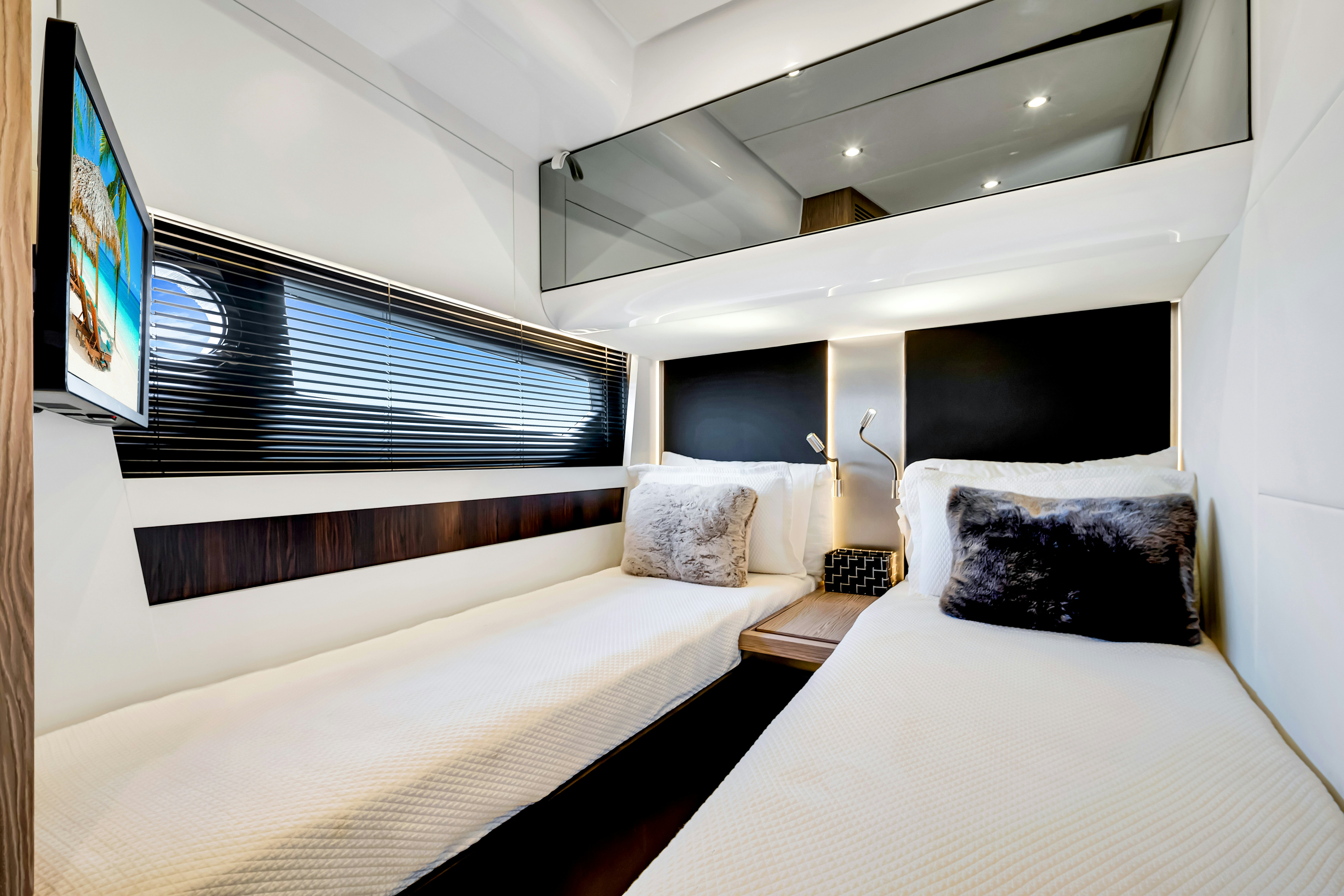 a room with a bed and a television on the wall aboard AMF Yacht for Sale