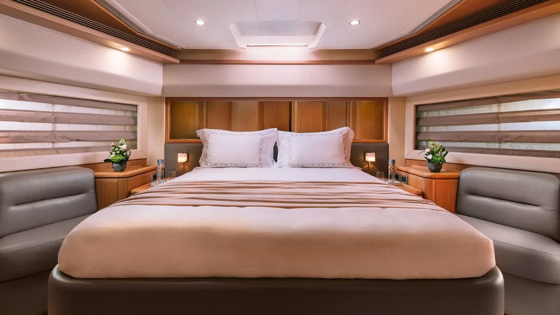 a bed with a white sheet and pillows aboard MELI Yacht for Charter