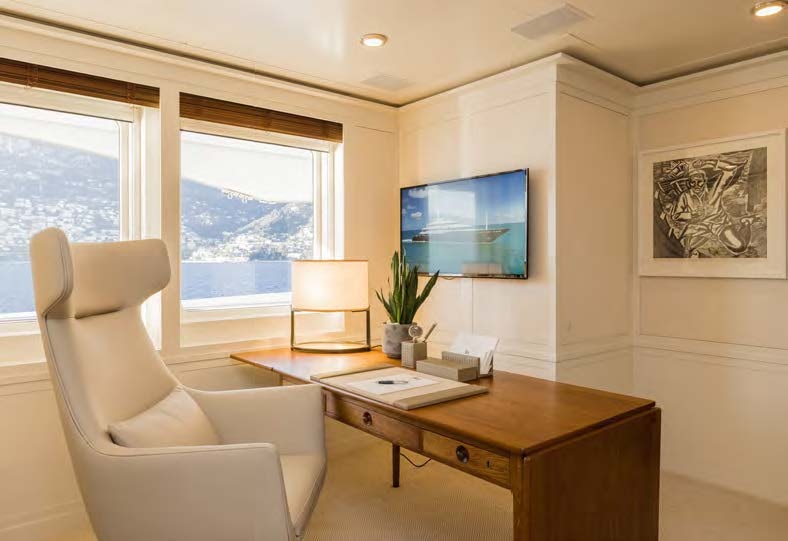 a living room with a tv and a table aboard HBC Yacht for Sale