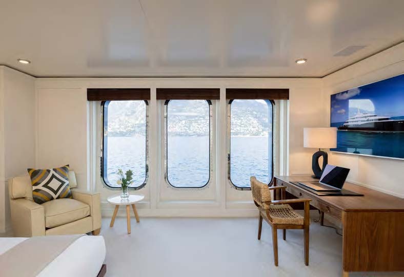 a living room with a laptop on a desk aboard HBC Yacht for Sale