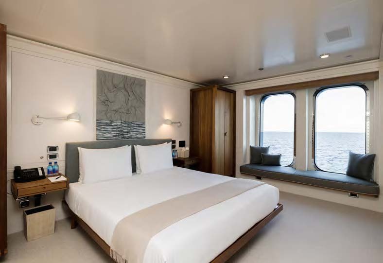 a bedroom with a bed and a desk aboard HBC Yacht for Sale