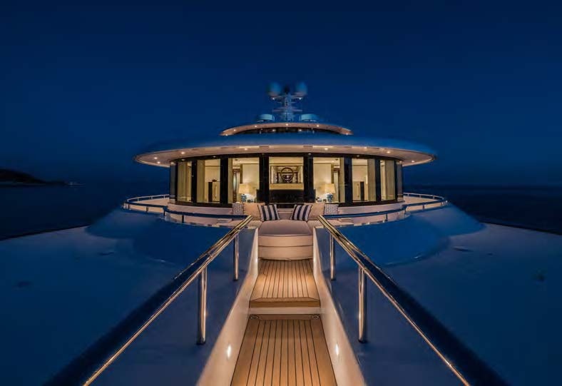 a dock leading to a building at night aboard HBC Yacht for Sale