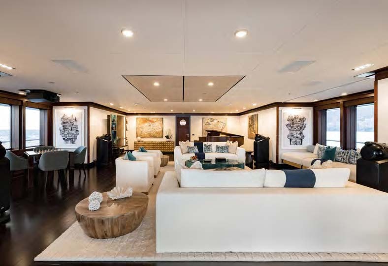 a large living room with a large white sofa and a large table aboard HBC Yacht for Sale