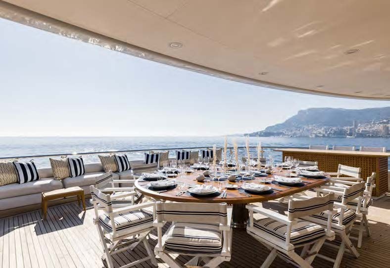 a large patio with chairs and tables aboard HBC Yacht for Sale