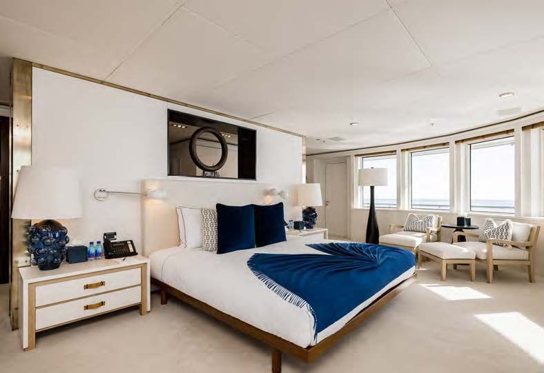 a bedroom with a bed and a desk aboard HBC Yacht for Sale