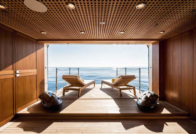 a room with a view of the ocean and a wooden deck aboard HBC Yacht for Sale