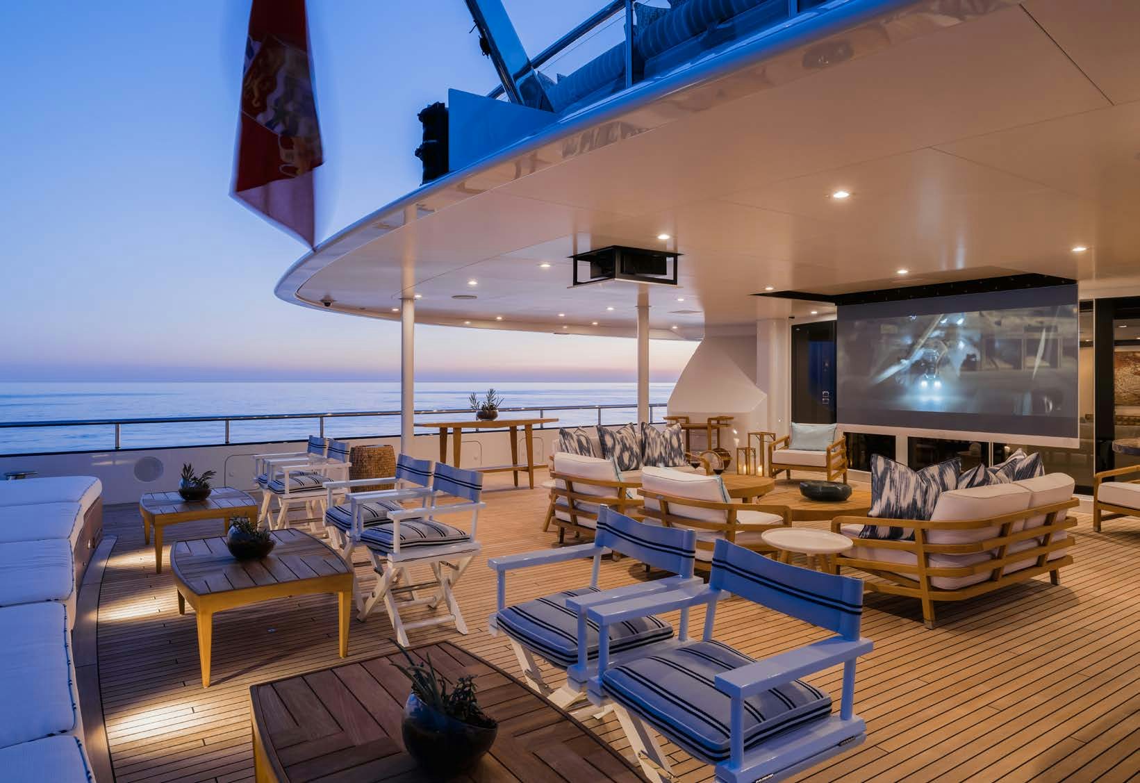 a room with a large table and chairs and a tv aboard HBC Yacht for Sale