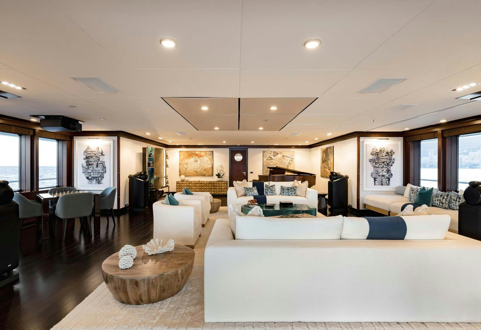 a living room with a large white couch and a large table aboard HBC Yacht for Sale