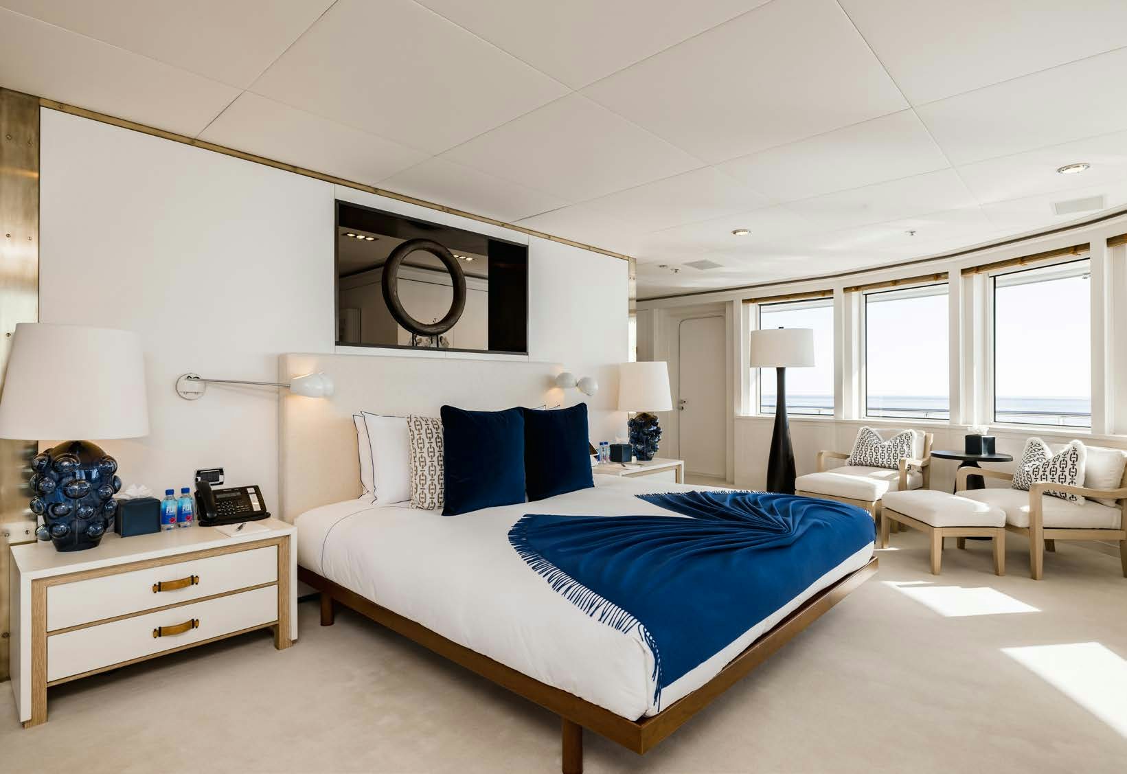 a bedroom with a bed and a desk aboard HBC Yacht for Sale