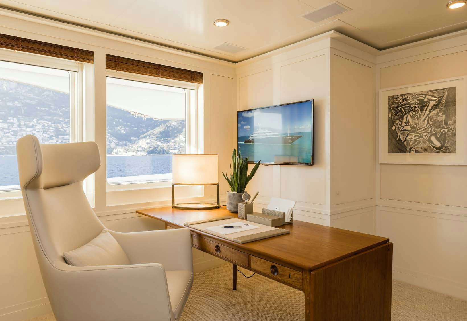 a room with a desk and a tv on the wall aboard HBC Yacht for Sale