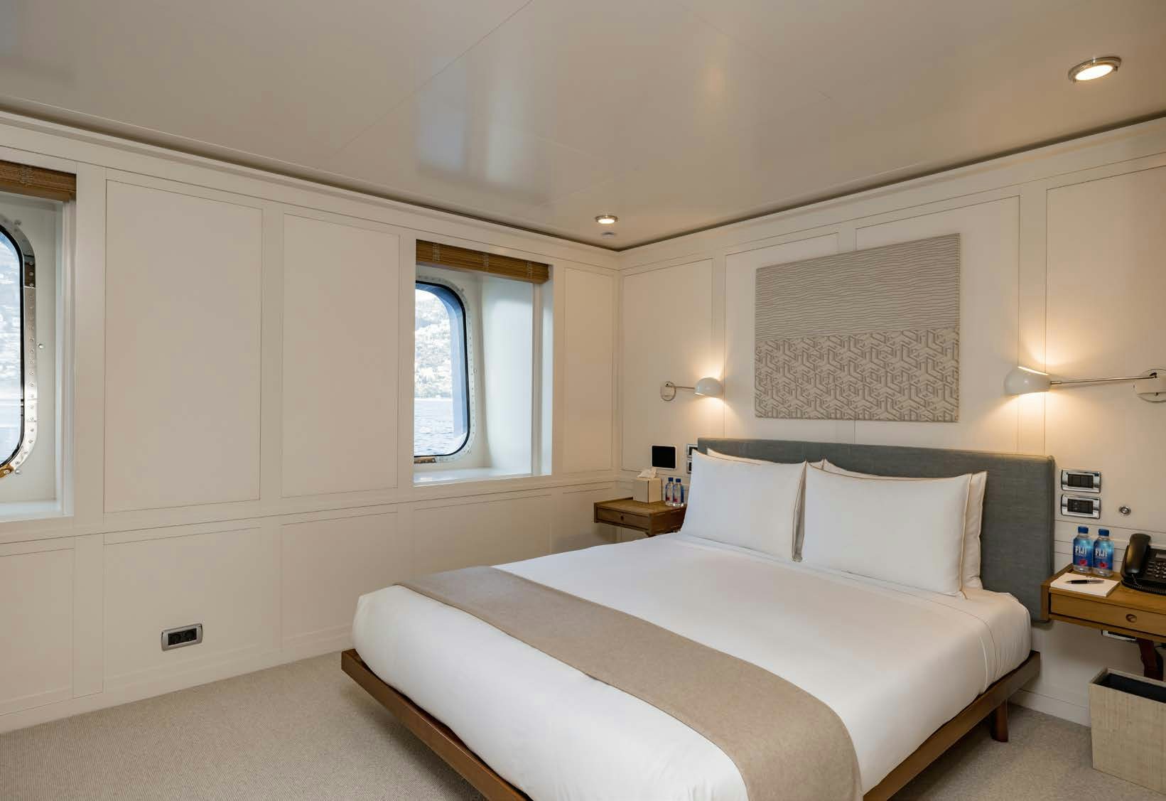 a bedroom with a bed and a window aboard HBC Yacht for Sale