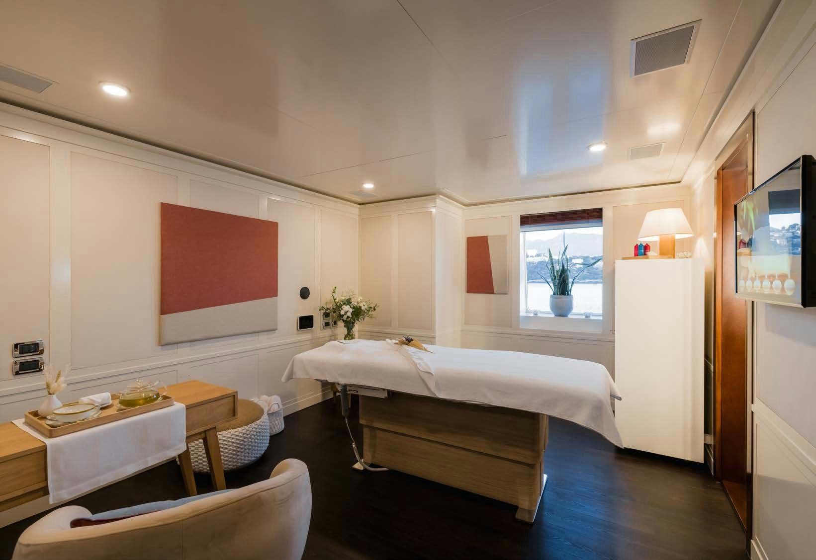 a bedroom with a bed and a table aboard HBC Yacht for Sale