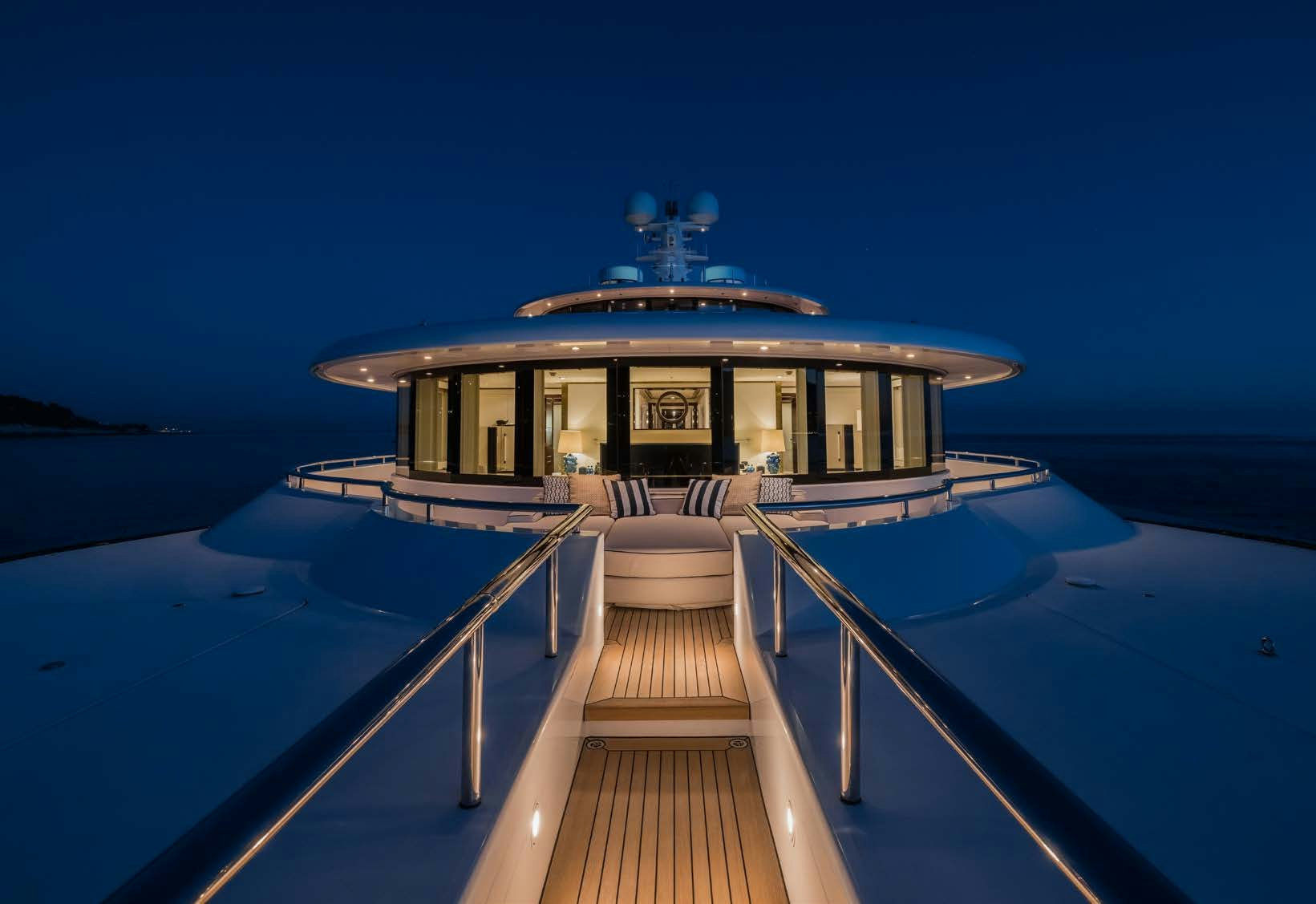 a dock leading to a large building at night aboard HBC Yacht for Sale
