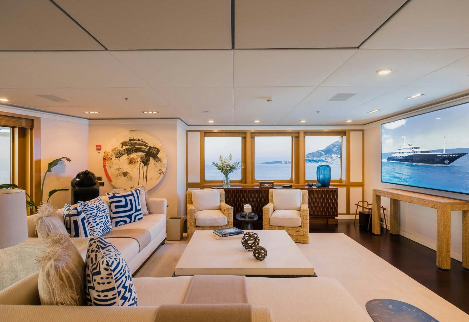 a living room with a large screen aboard HBC Yacht for Sale