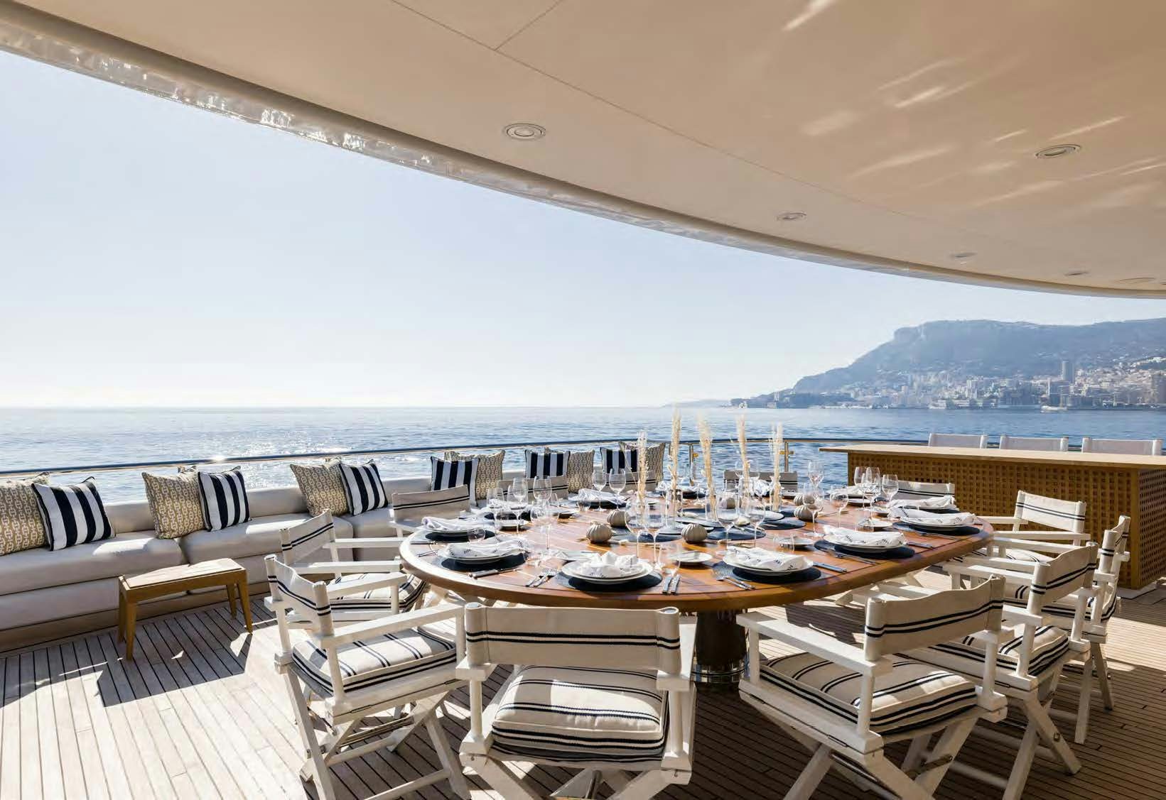 a large patio with tables and chairs aboard HBC Yacht for Sale