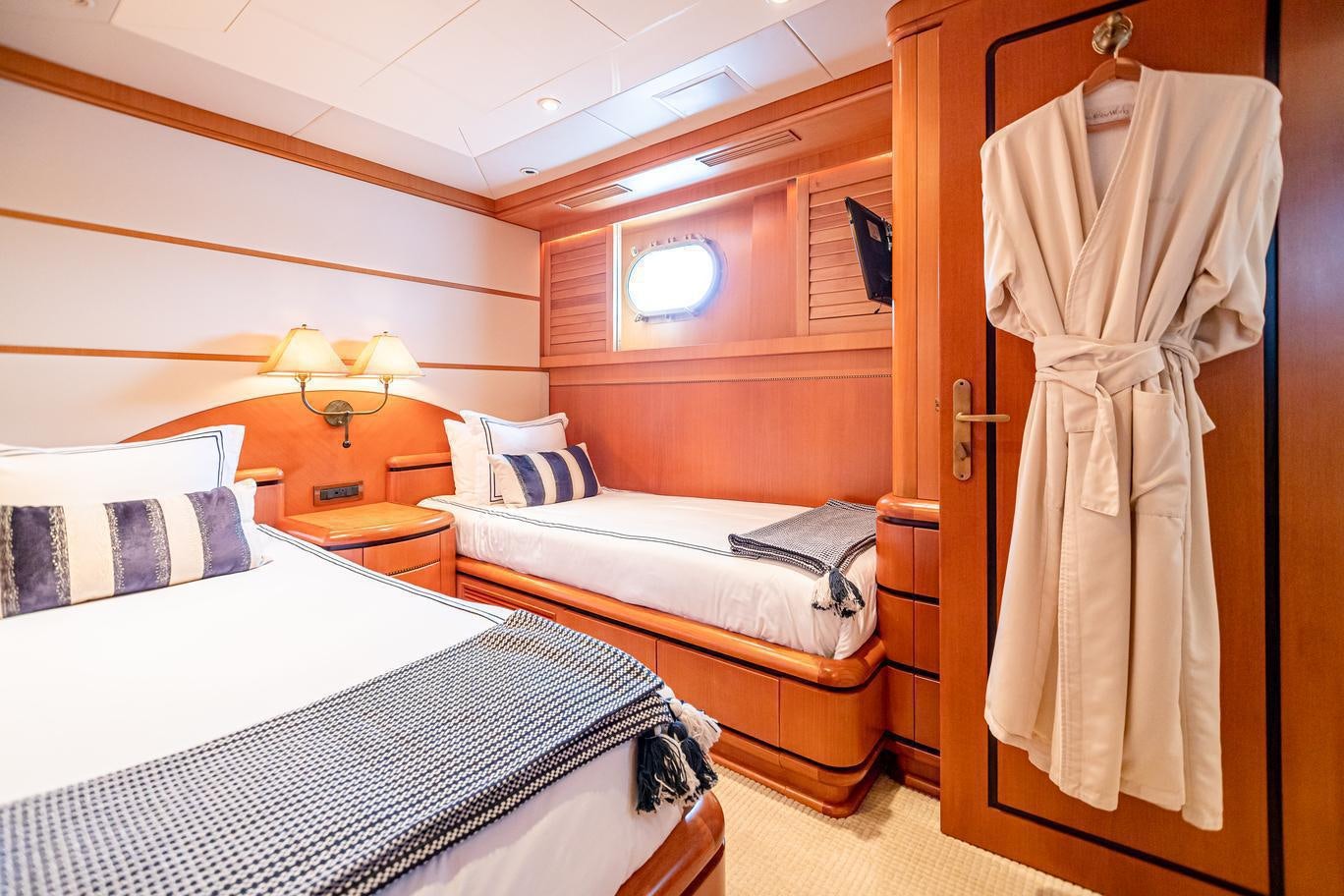 a room with beds and a closet aboard XOXO (118') Yacht for Charter