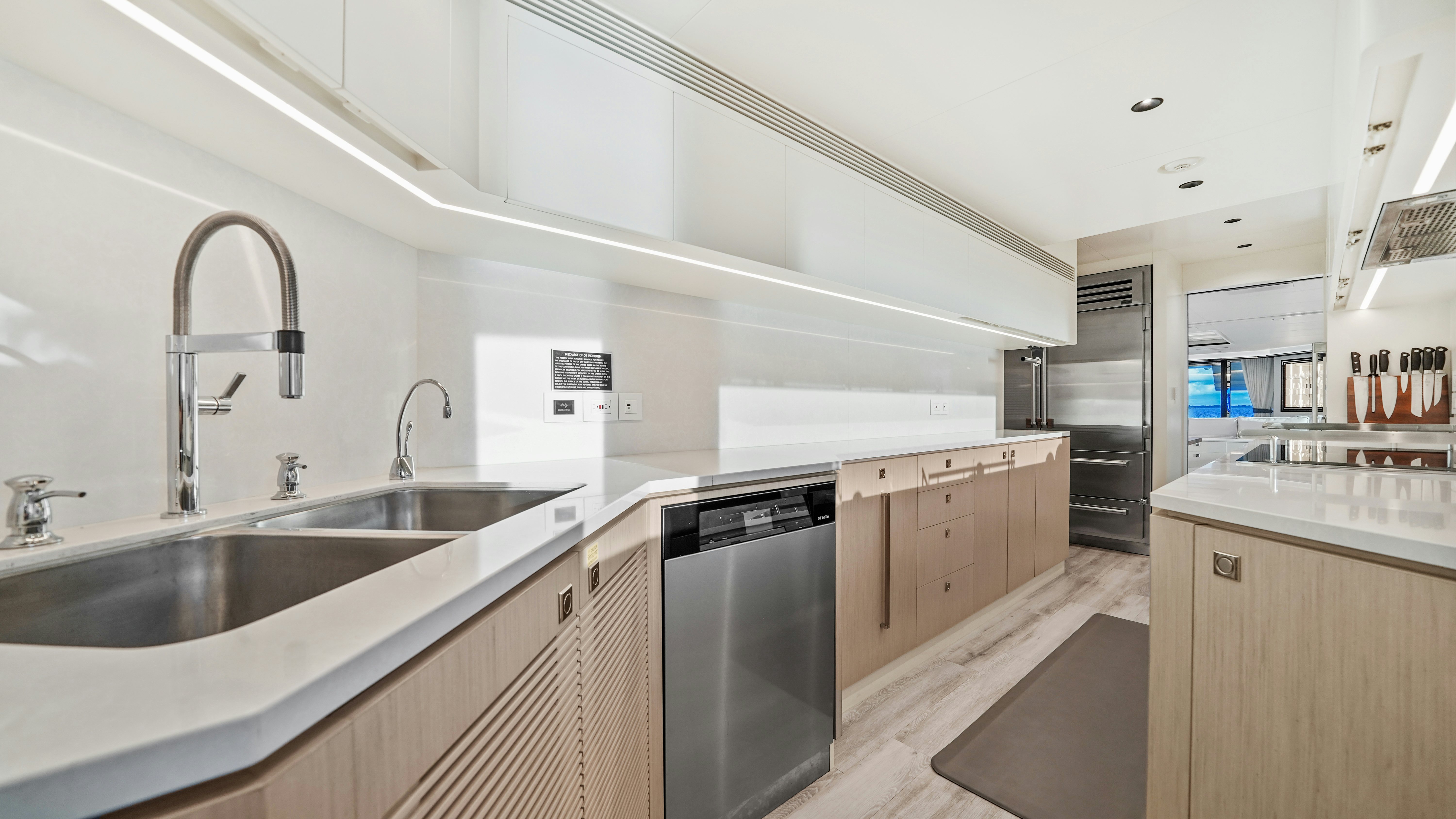 a kitchen with a sink and a refrigerator aboard MISS MICHELLE Yacht for Sale