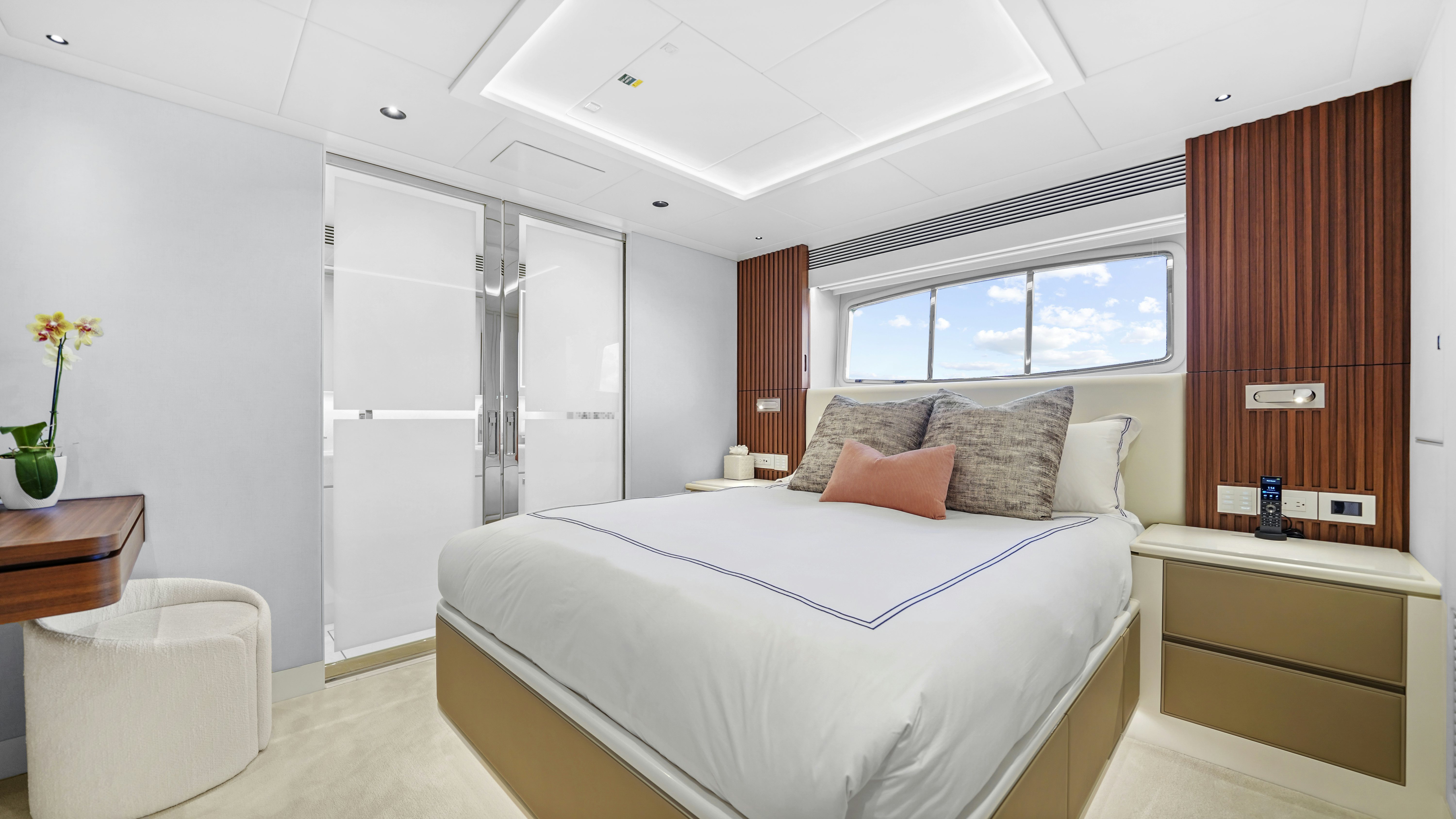 a bedroom with a bed and a window aboard MISS MICHELLE Yacht for Sale
