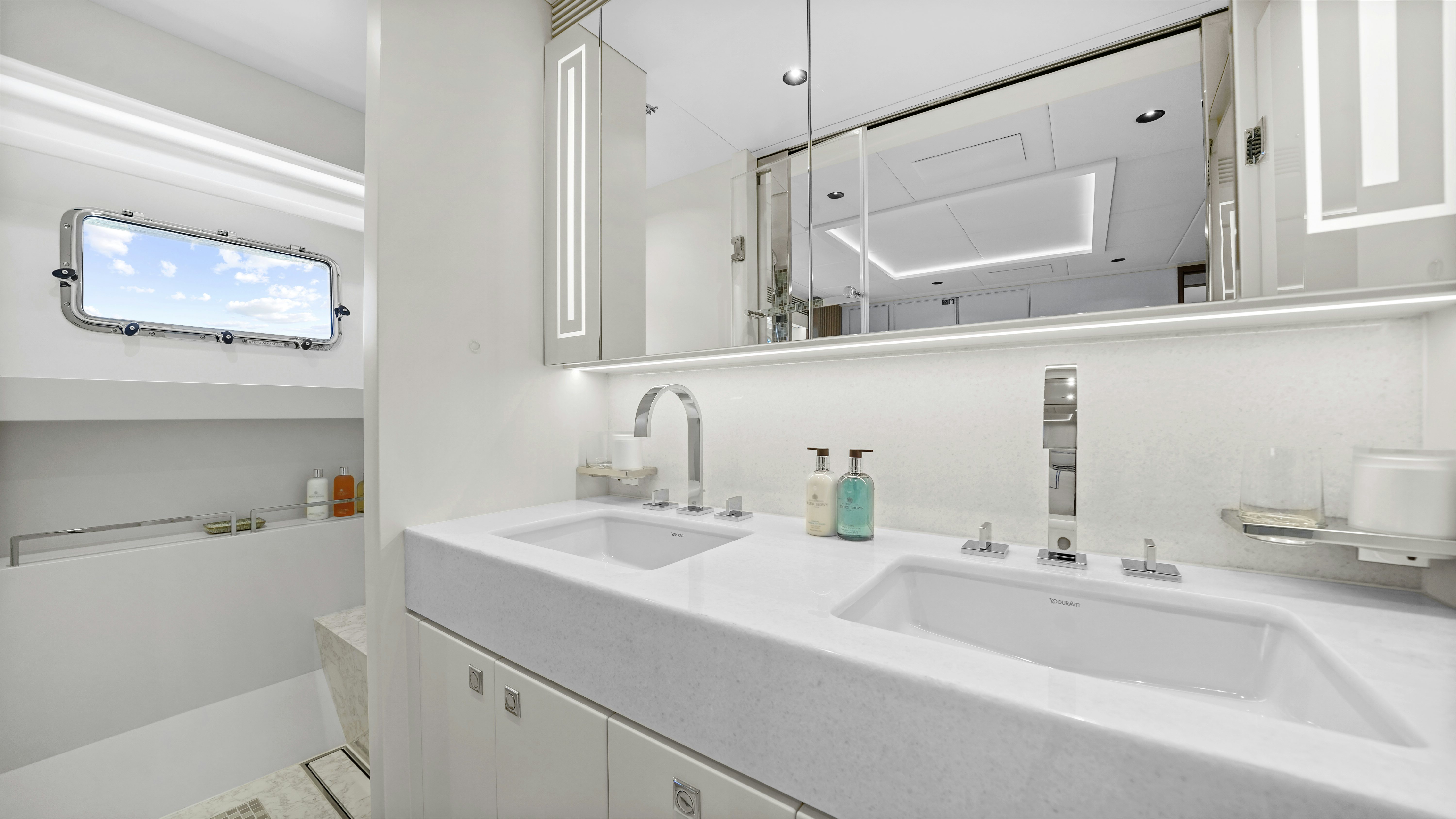 a bathroom with a large mirror aboard MISS MICHELLE Yacht for Sale