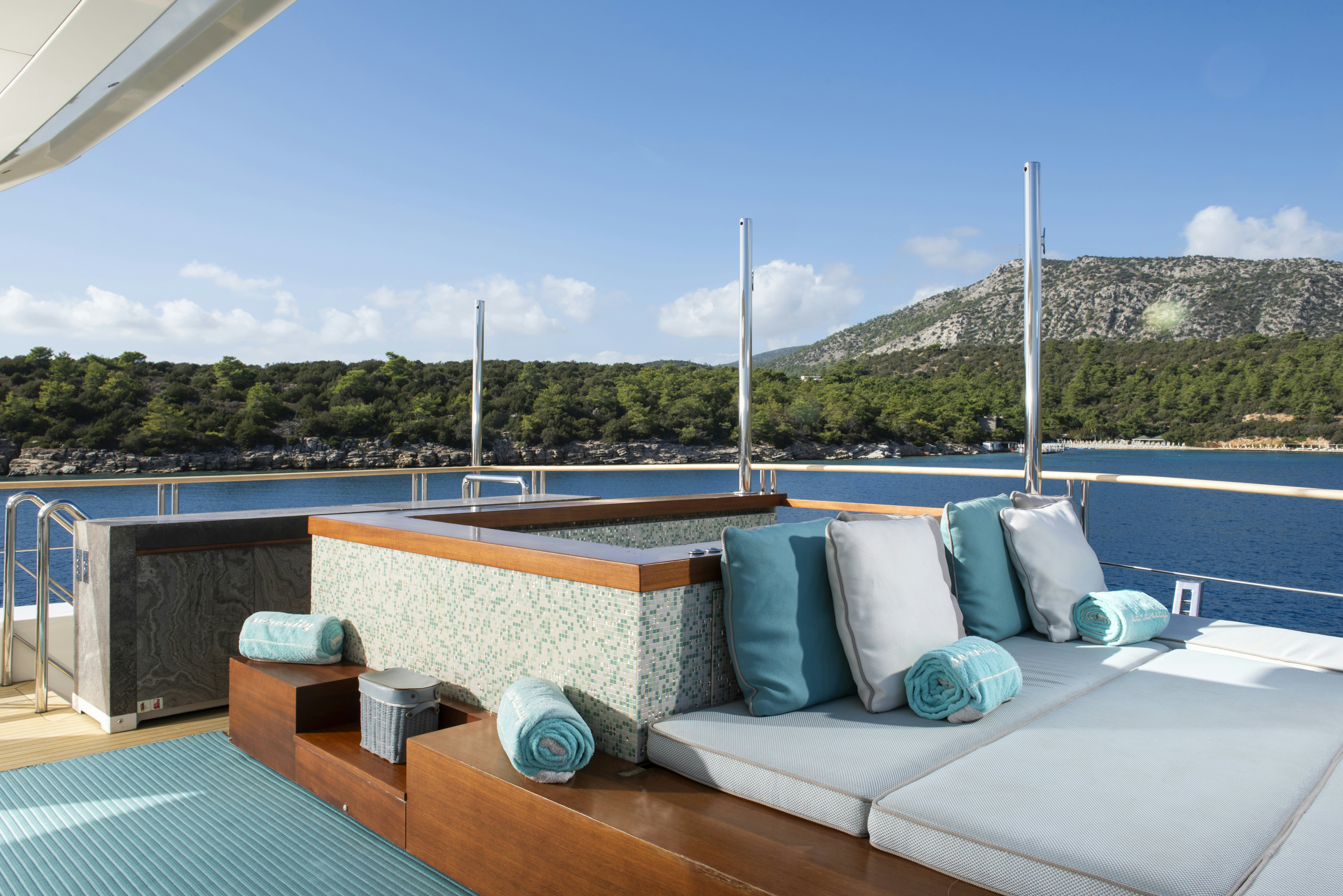 a deck with pillows and a pool aboard SERENITY Yacht for Sale
