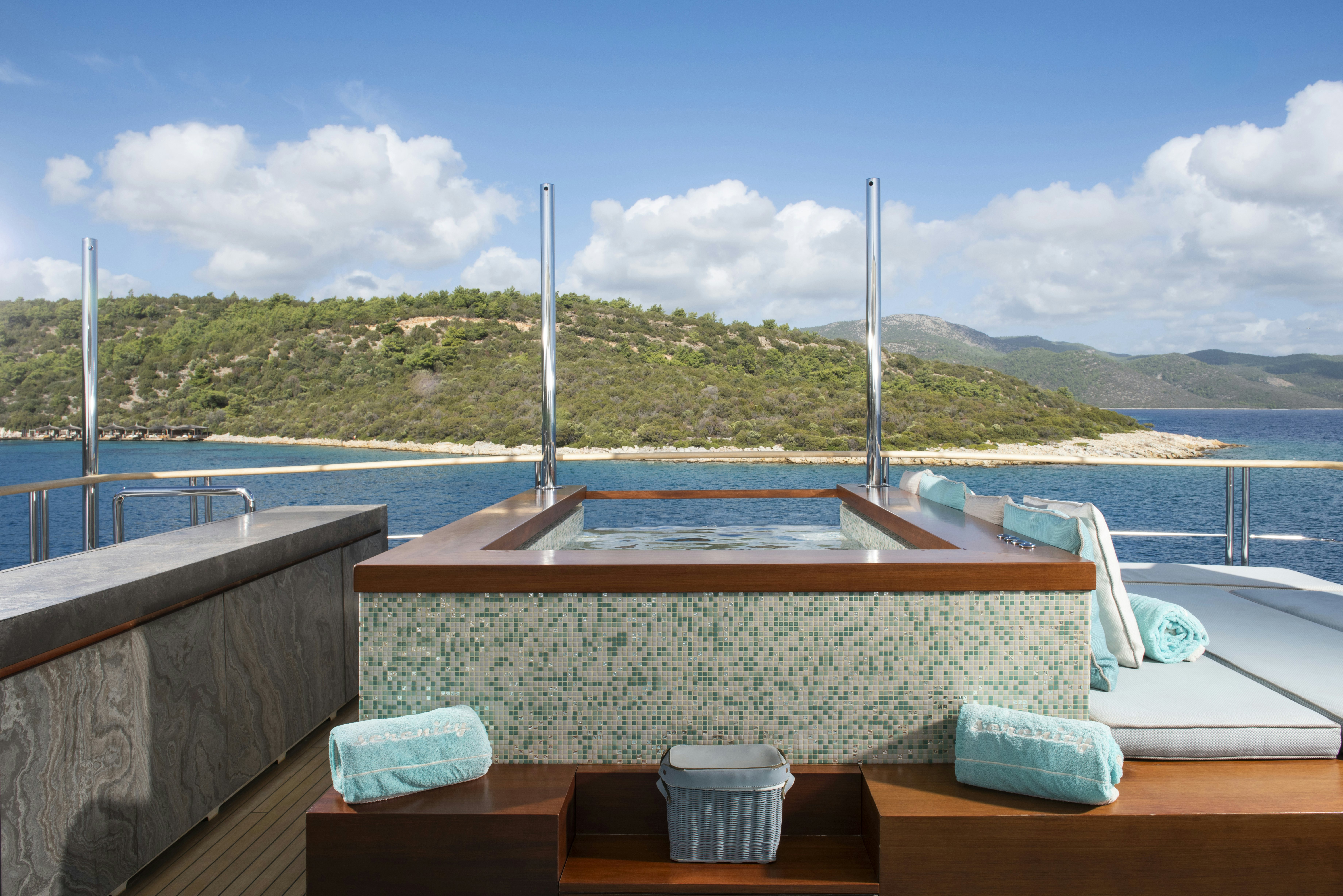 a table on a deck overlooking a body of water aboard SERENITY Yacht for Sale