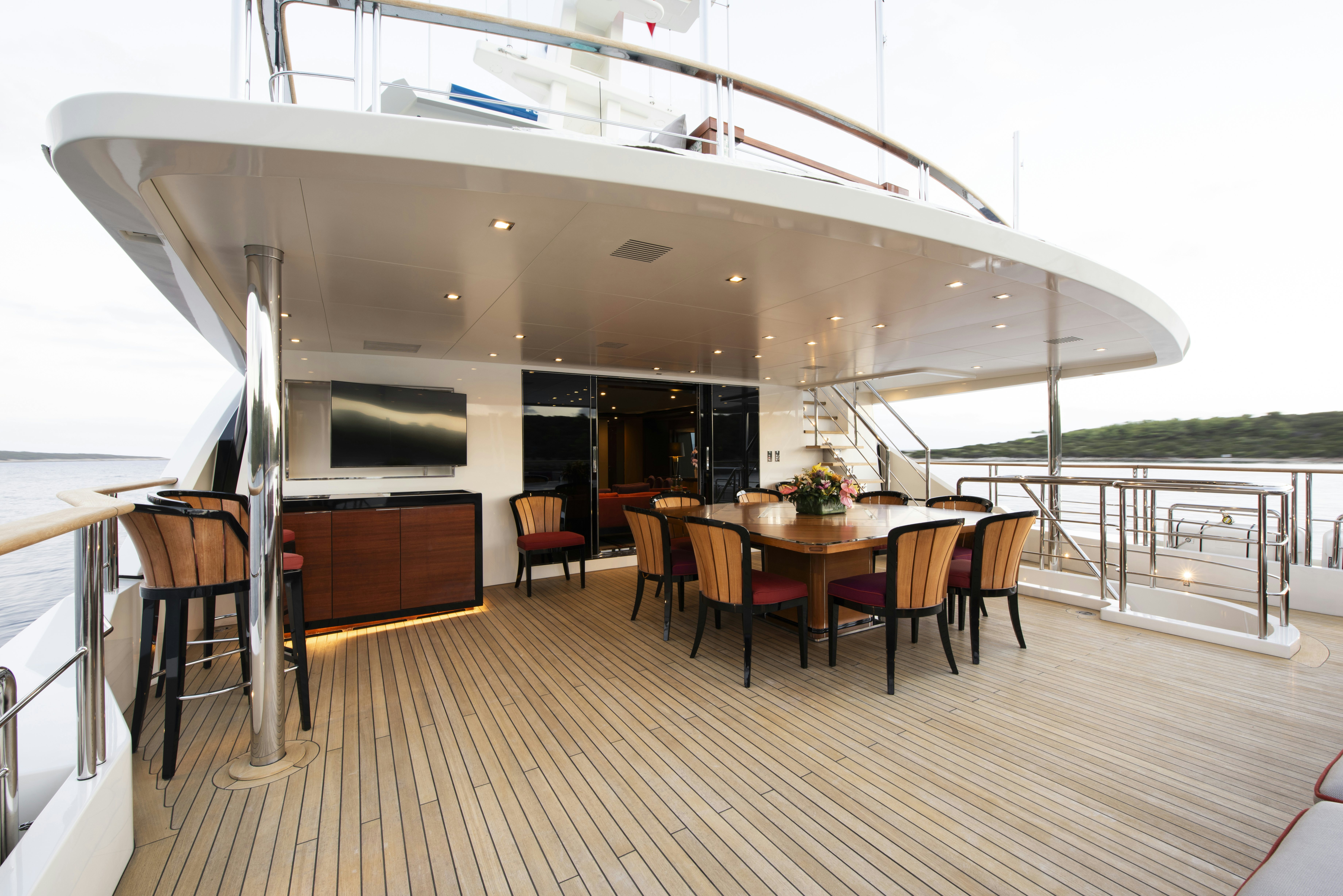 a large open space with a table and chairs and a large white ceiling aboard SERENITY Yacht for Sale
