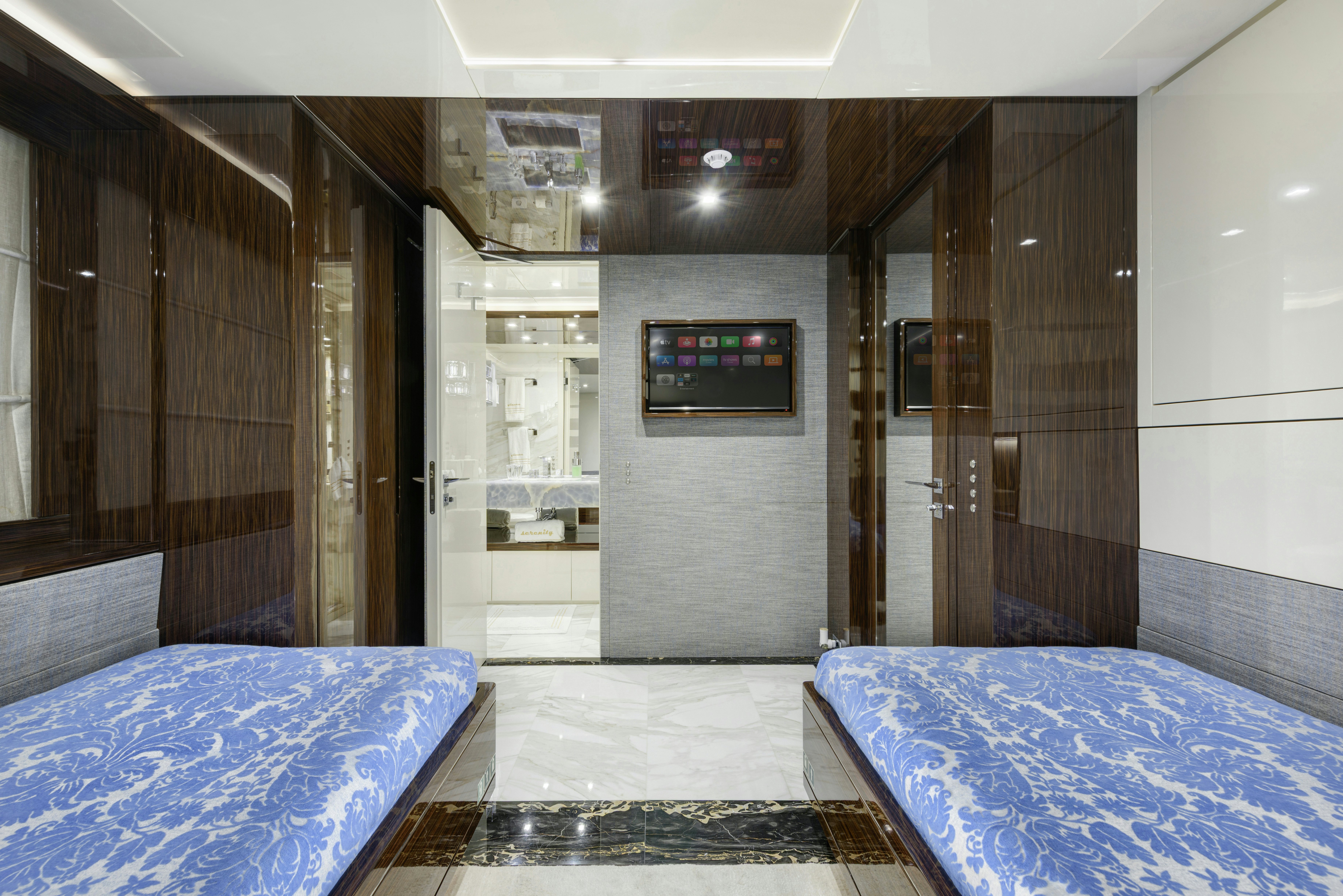 a room with a bed and a television on the wall aboard SERENITY Yacht for Sale