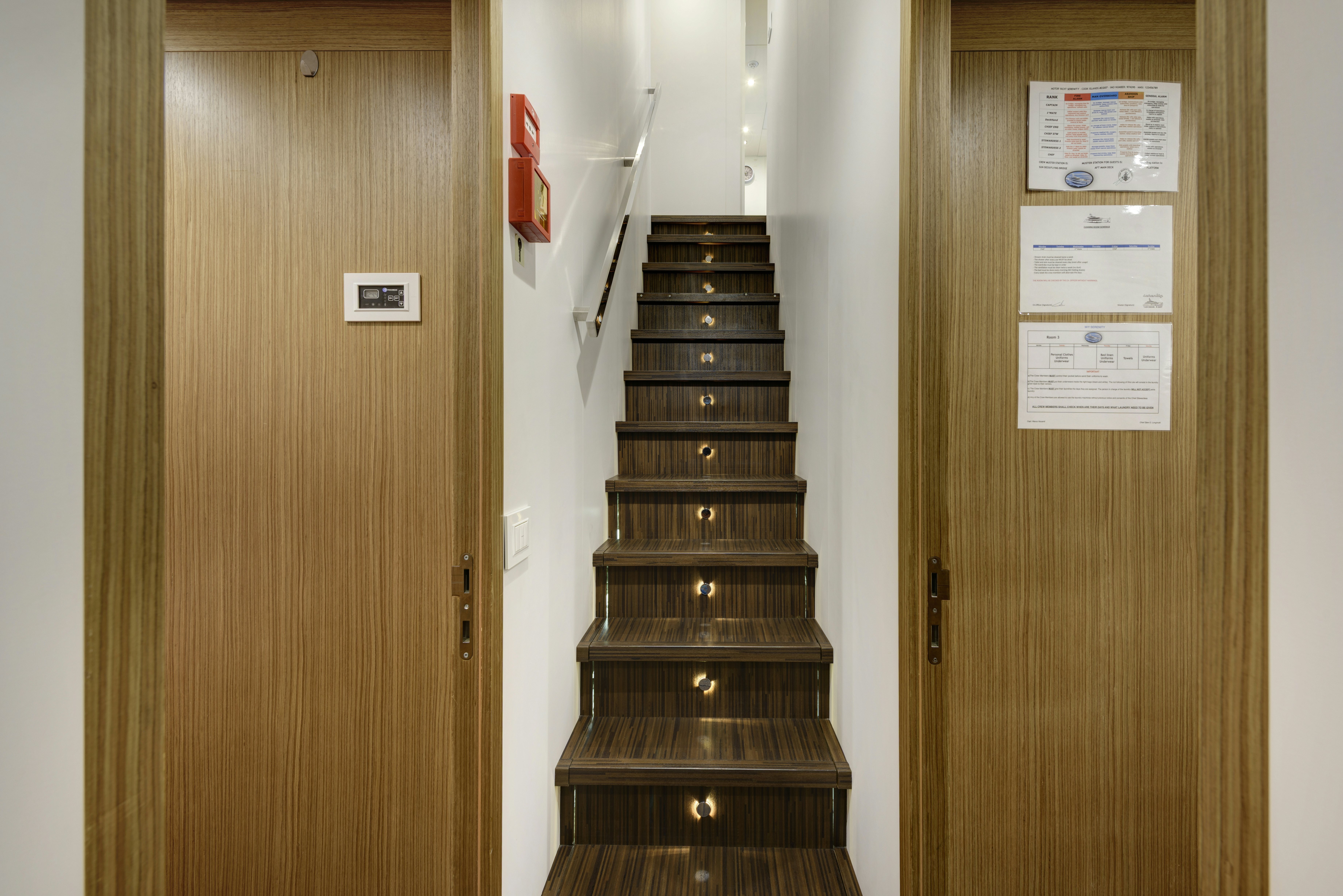 a wood cabinet with a door and a red door aboard SERENITY Yacht for Sale