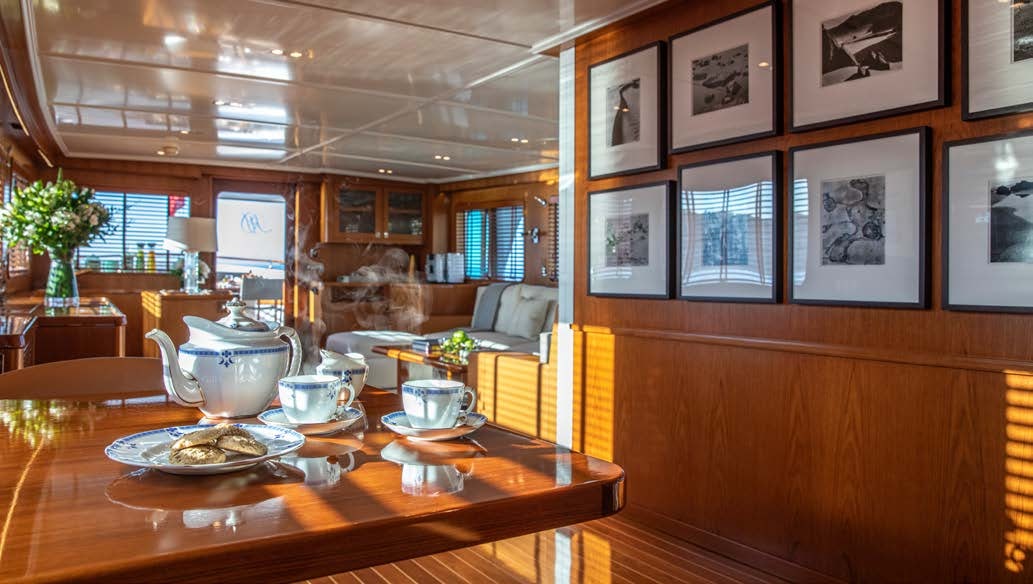 a large room with a table and chairs and a large window aboard HEAVENLY DAZE Yacht for Charter