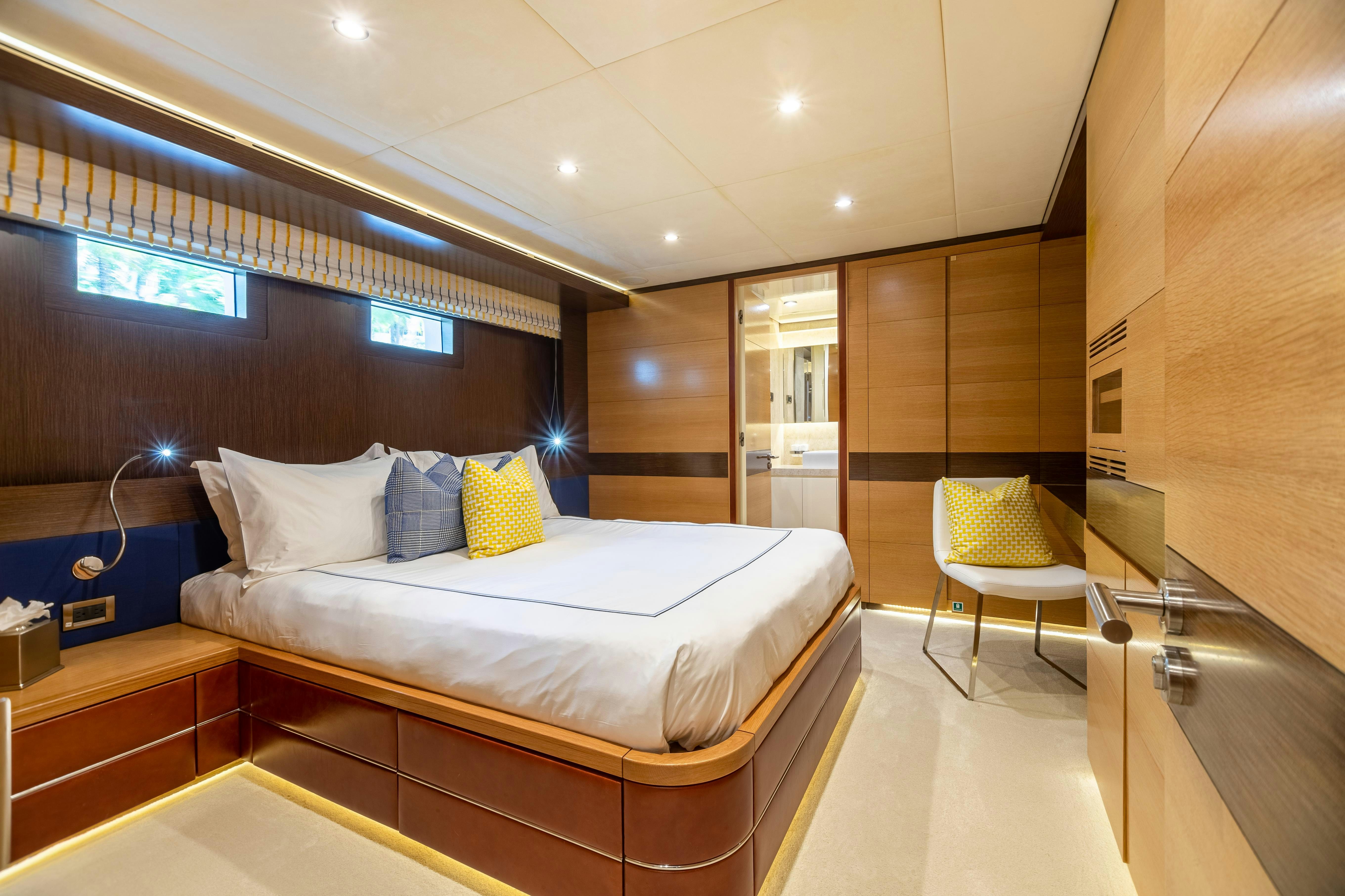 a room with a bed and a chair aboard SWEET CAROLINE Yacht for Charter