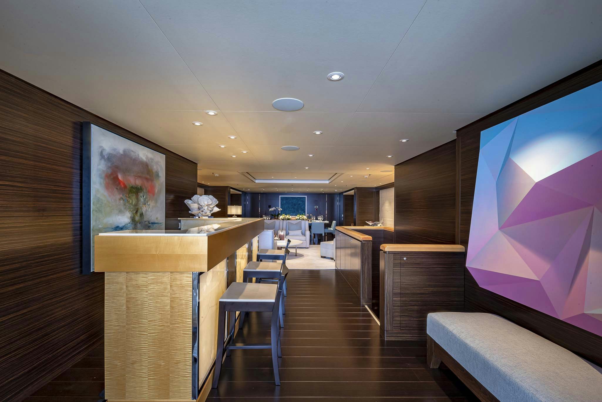 a room with a wood floor and a large screen on the wall aboard REVELRY Yacht for Charter