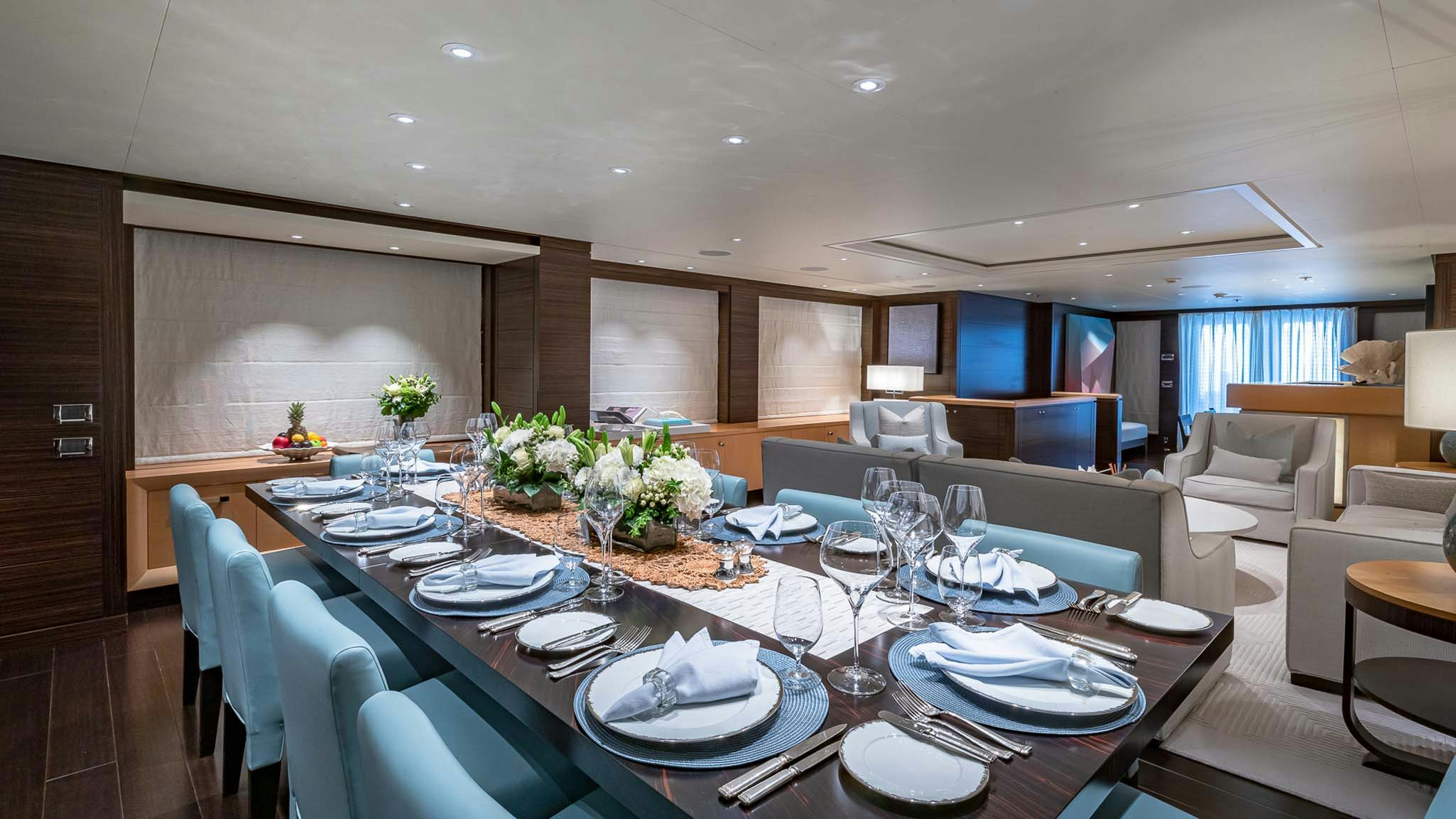 a large dining table with plates and chairs aboard REVELRY Yacht for Charter