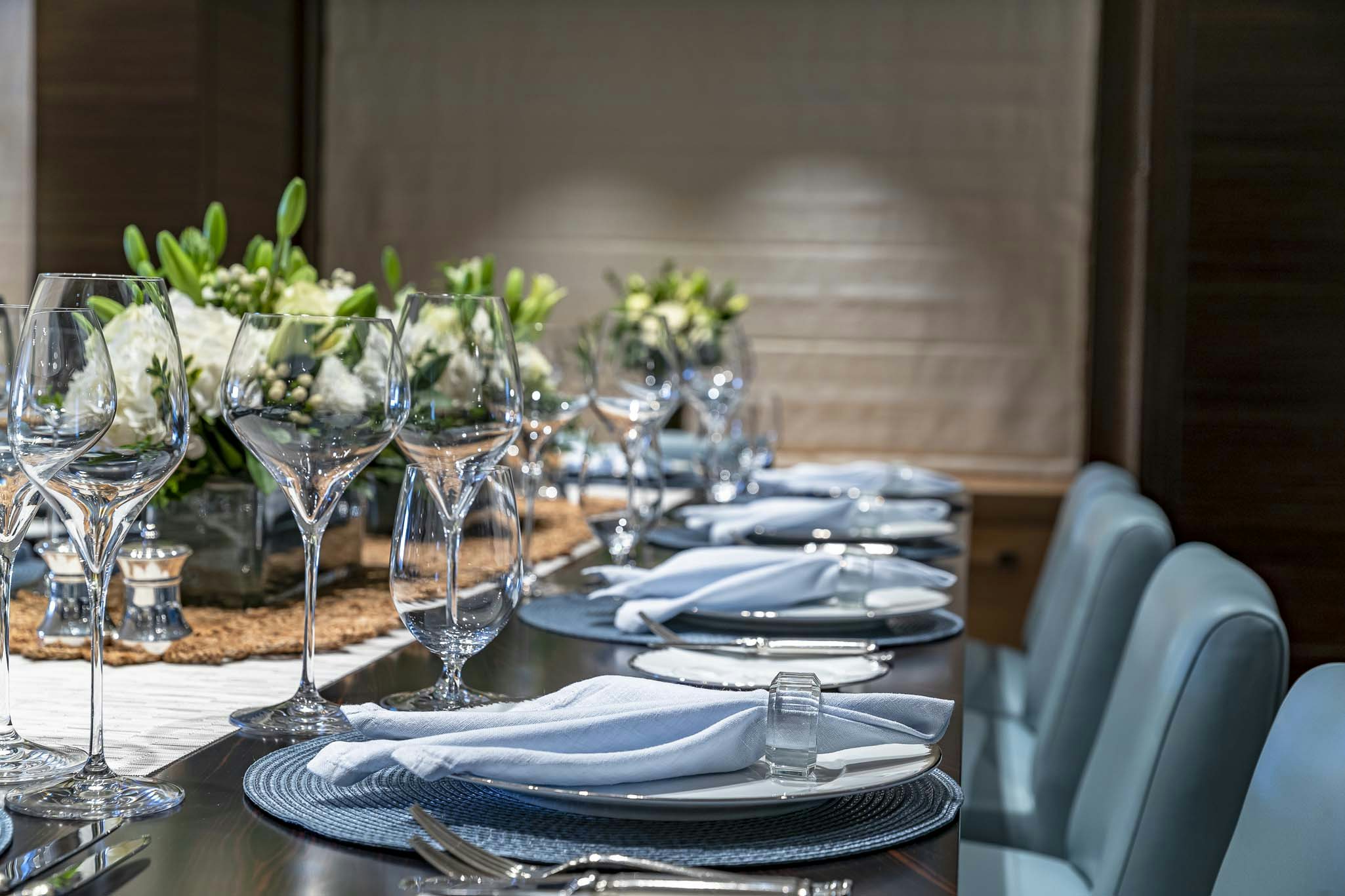 a table with plates and glasses aboard REVELRY Yacht for Charter