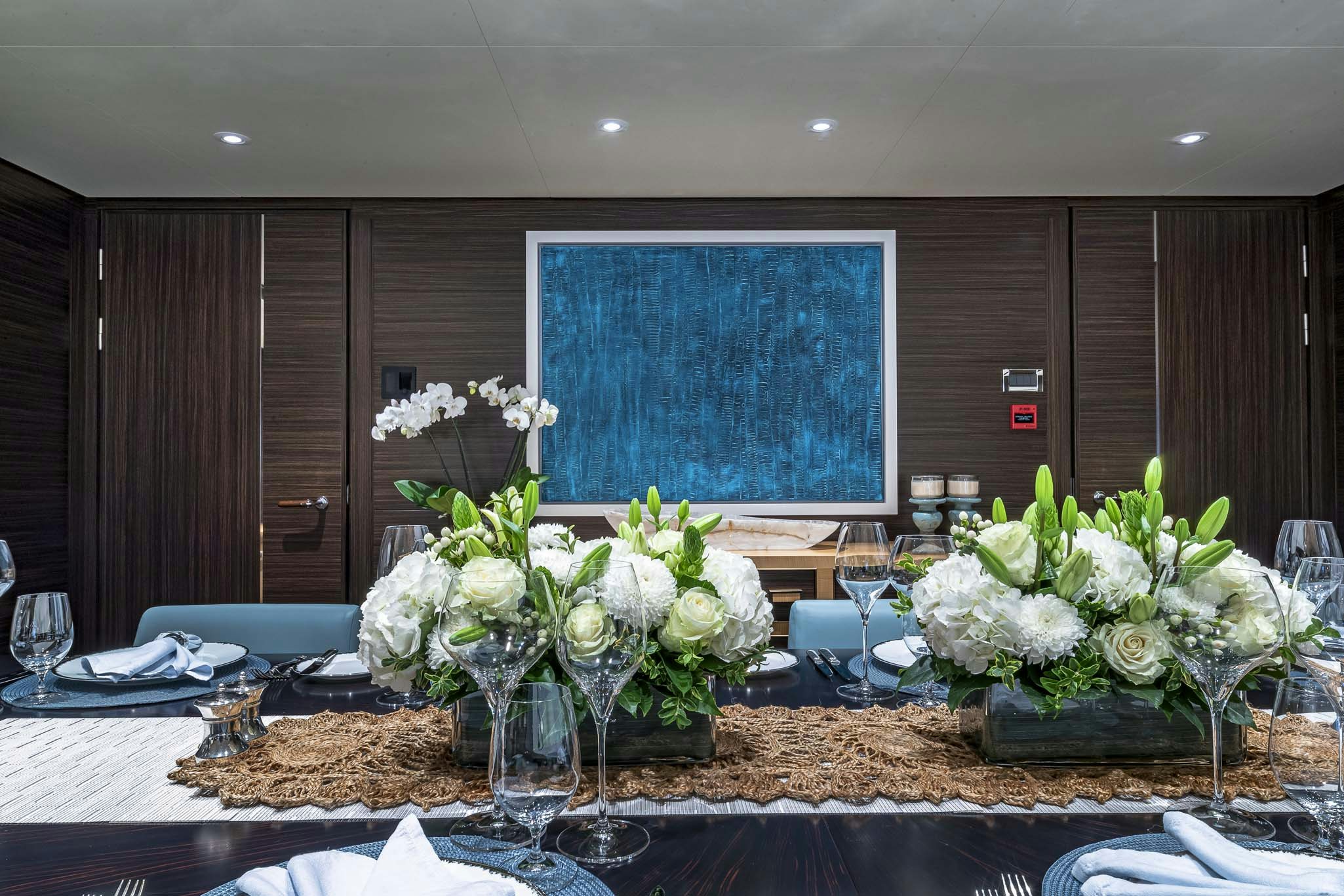 a table with vases of white flowers aboard REVELRY Yacht for Charter