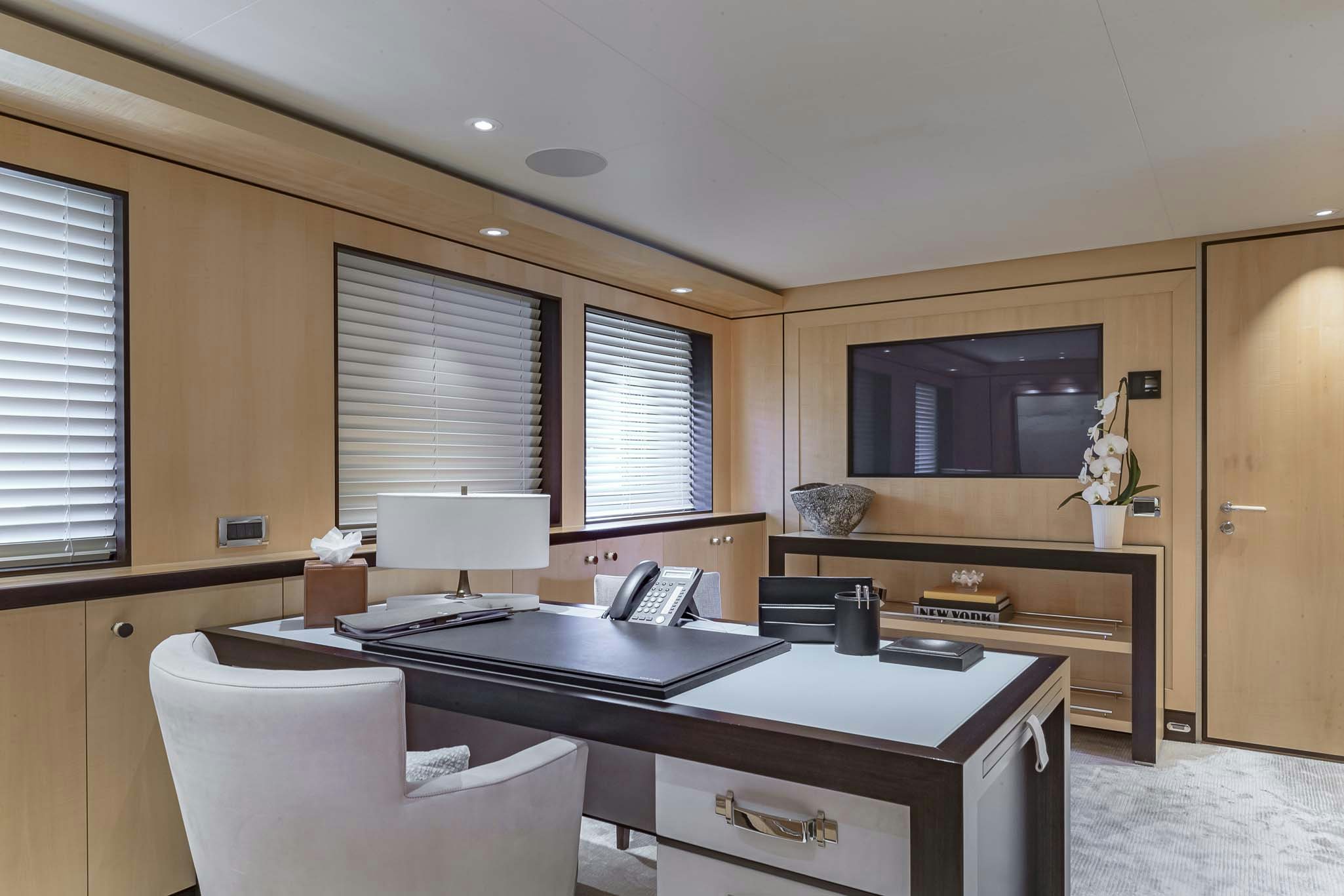 a room with a desk and a tv aboard REVELRY Yacht for Charter