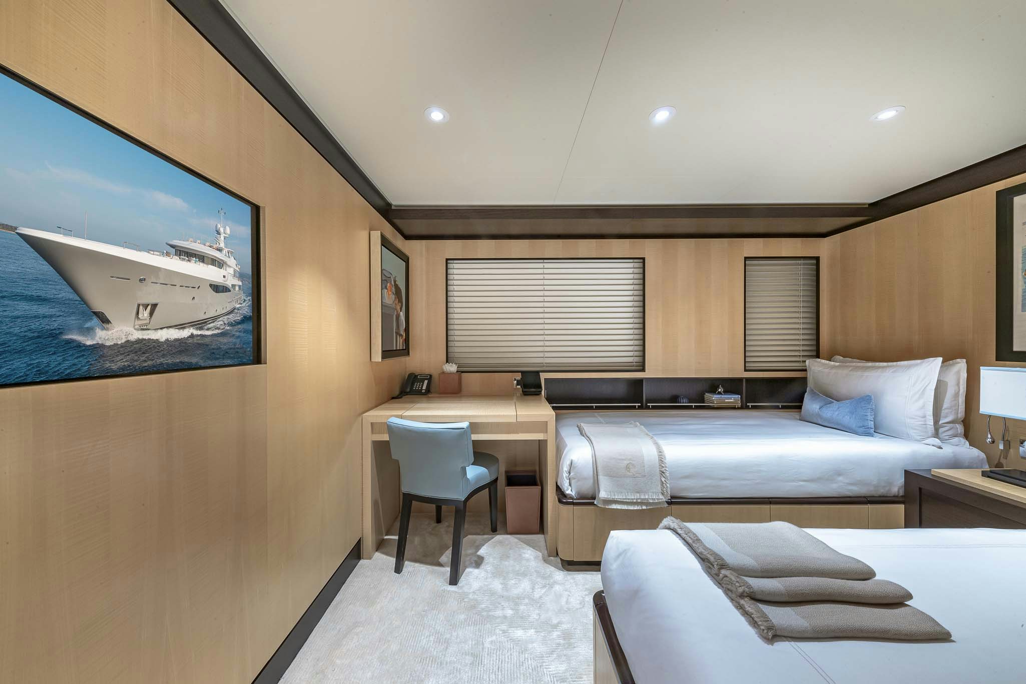 a room with a bed and a desk aboard REVELRY Yacht for Charter