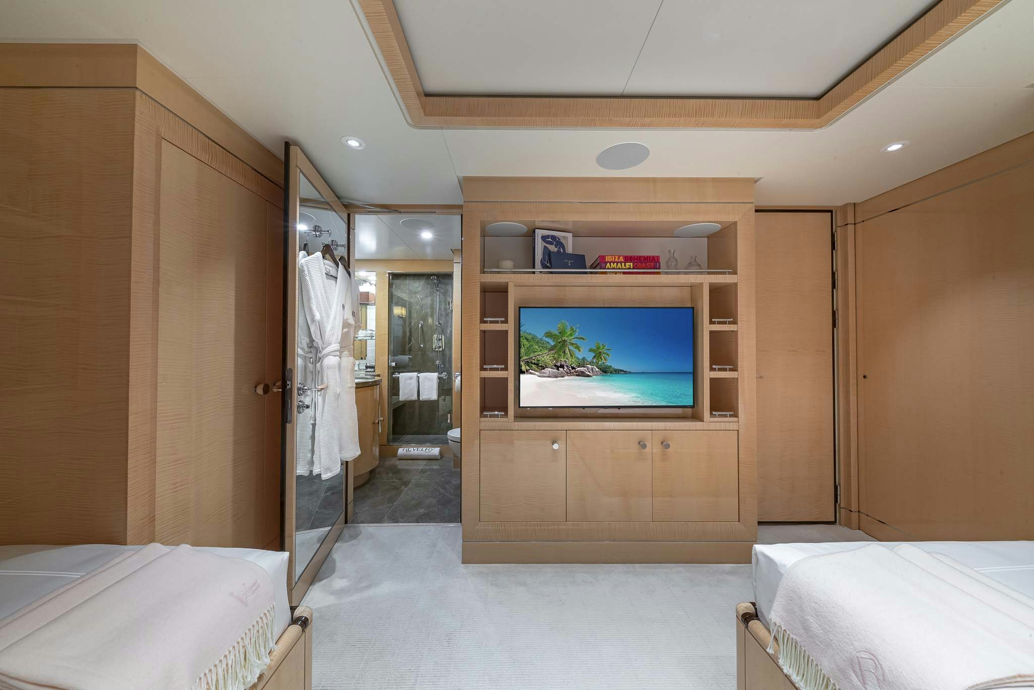 a room with a bed and a television aboard REVELRY Yacht for Charter