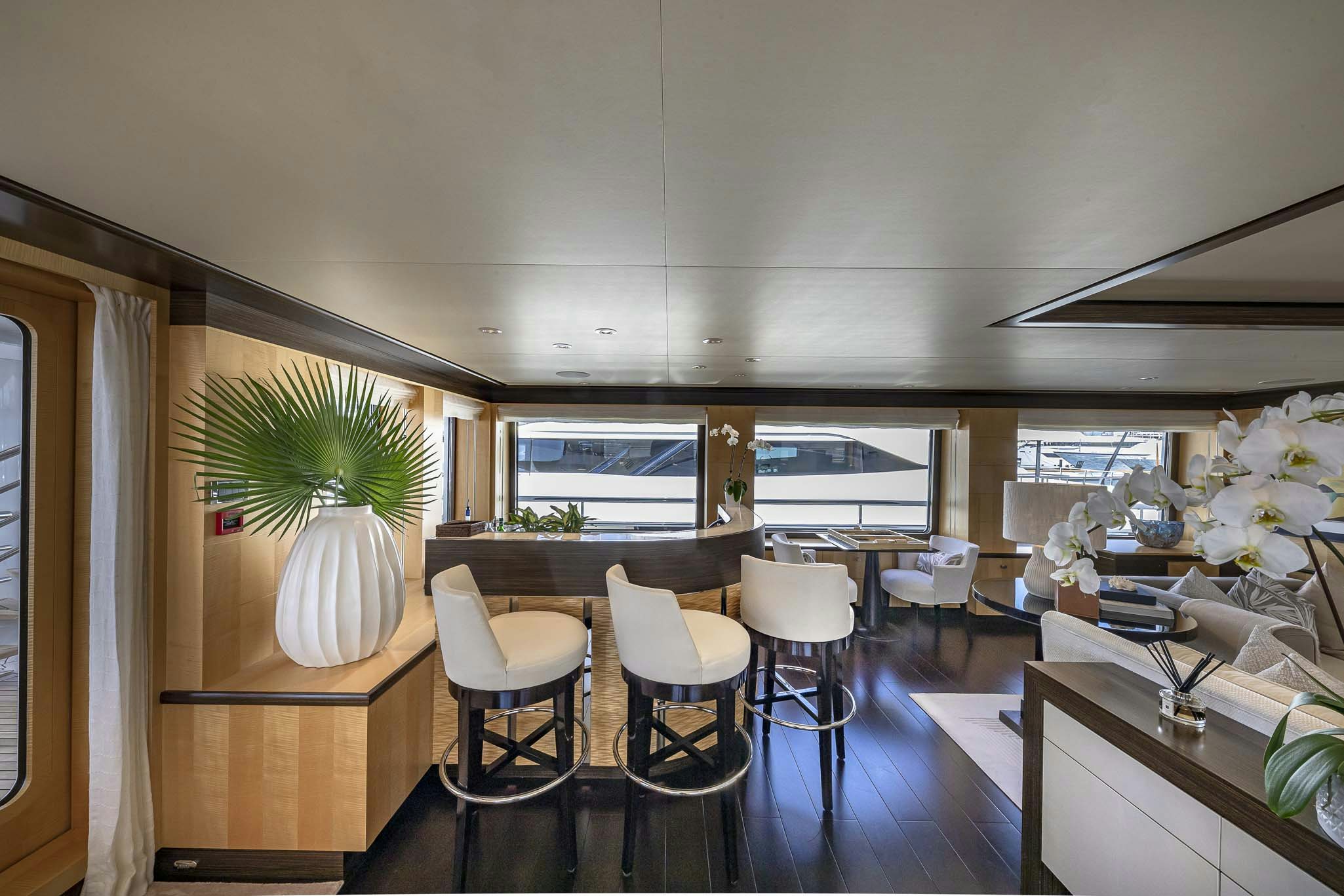 a room with a table chairs and a plant aboard REVELRY Yacht for Charter