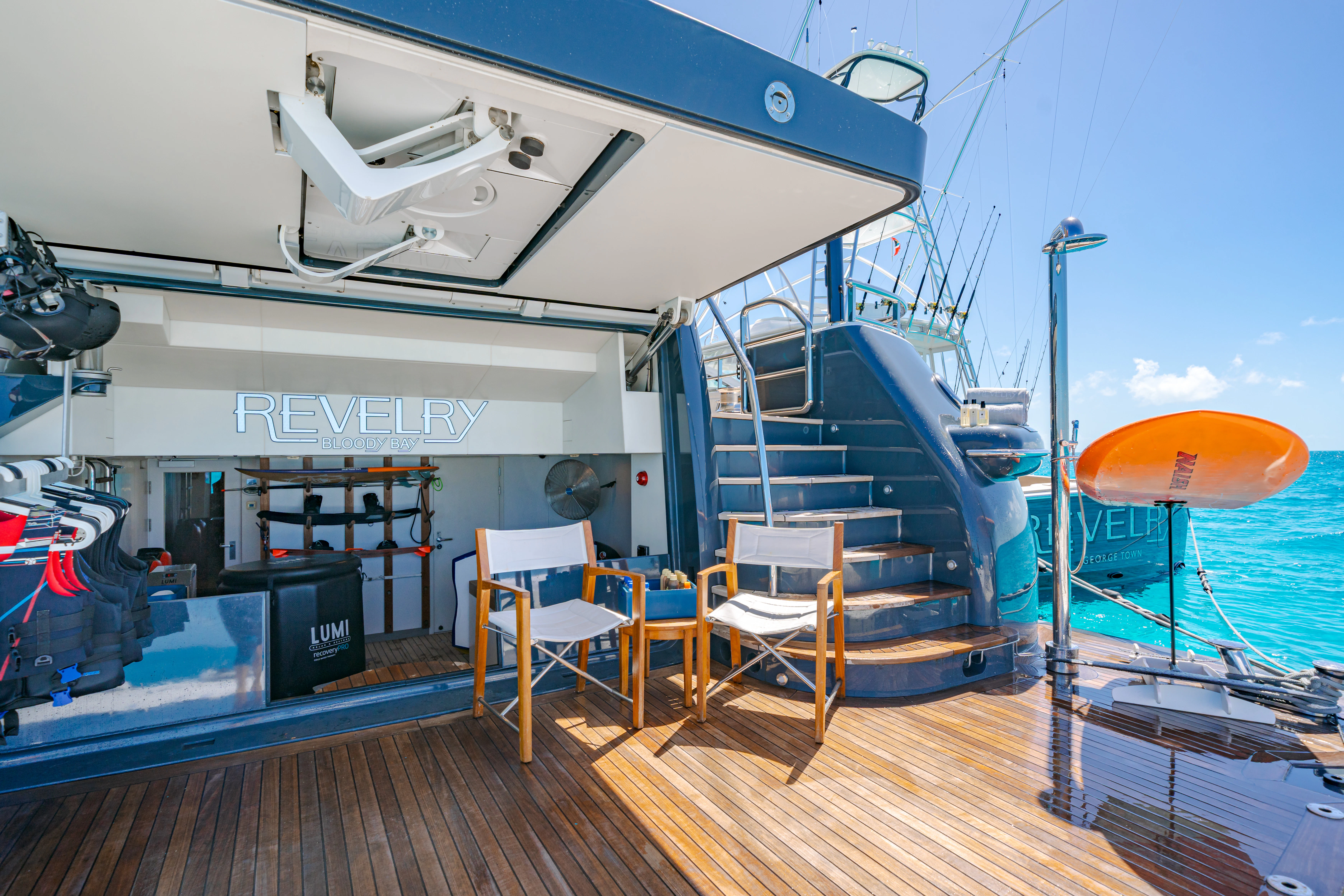 a room with a wood floor and a large white building with a blue sky and white clouds aboard REVELRY Yacht for Charter
