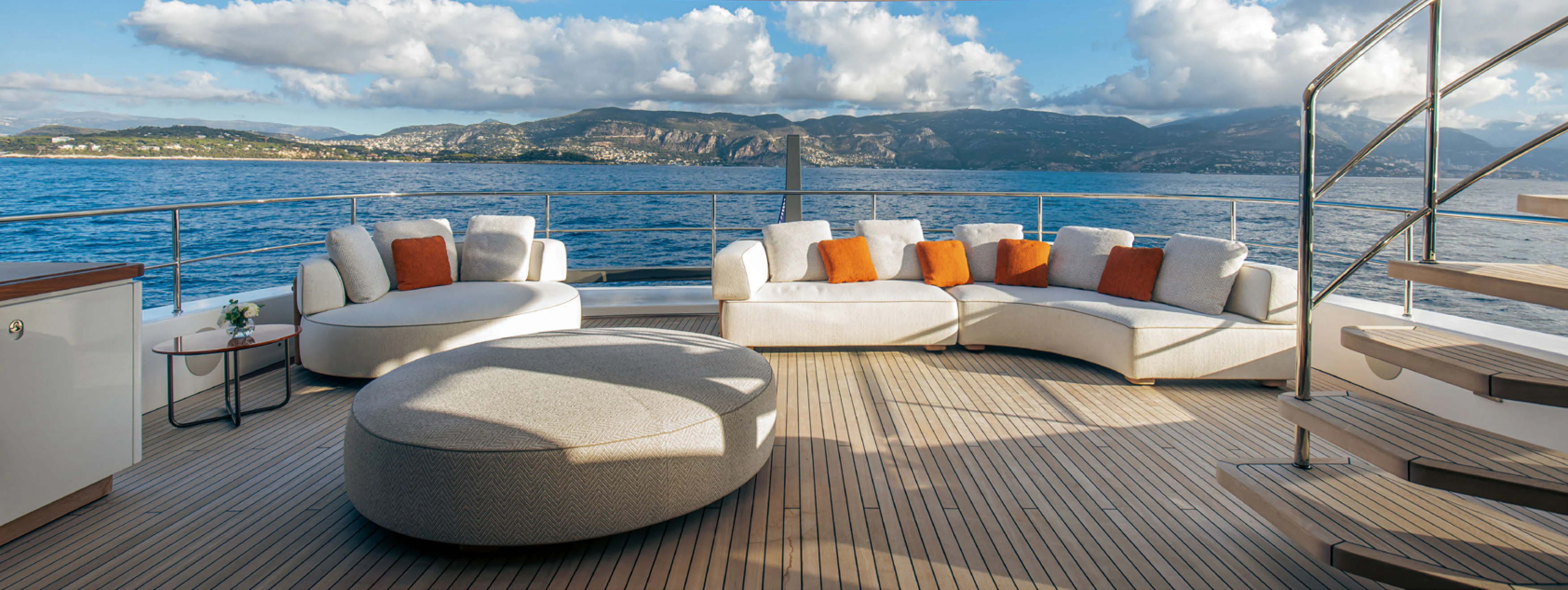 a large bed and a couch in a room with a large body of water aboard CADA DIA Yacht for Charter