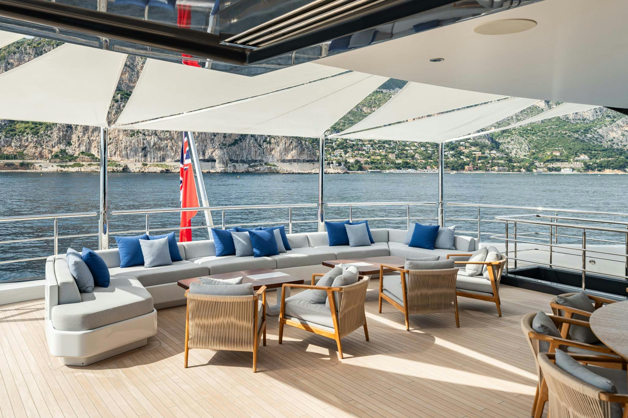 a large patio with a couch and chairs and a large body of water aboard MALIA Yacht for Charter