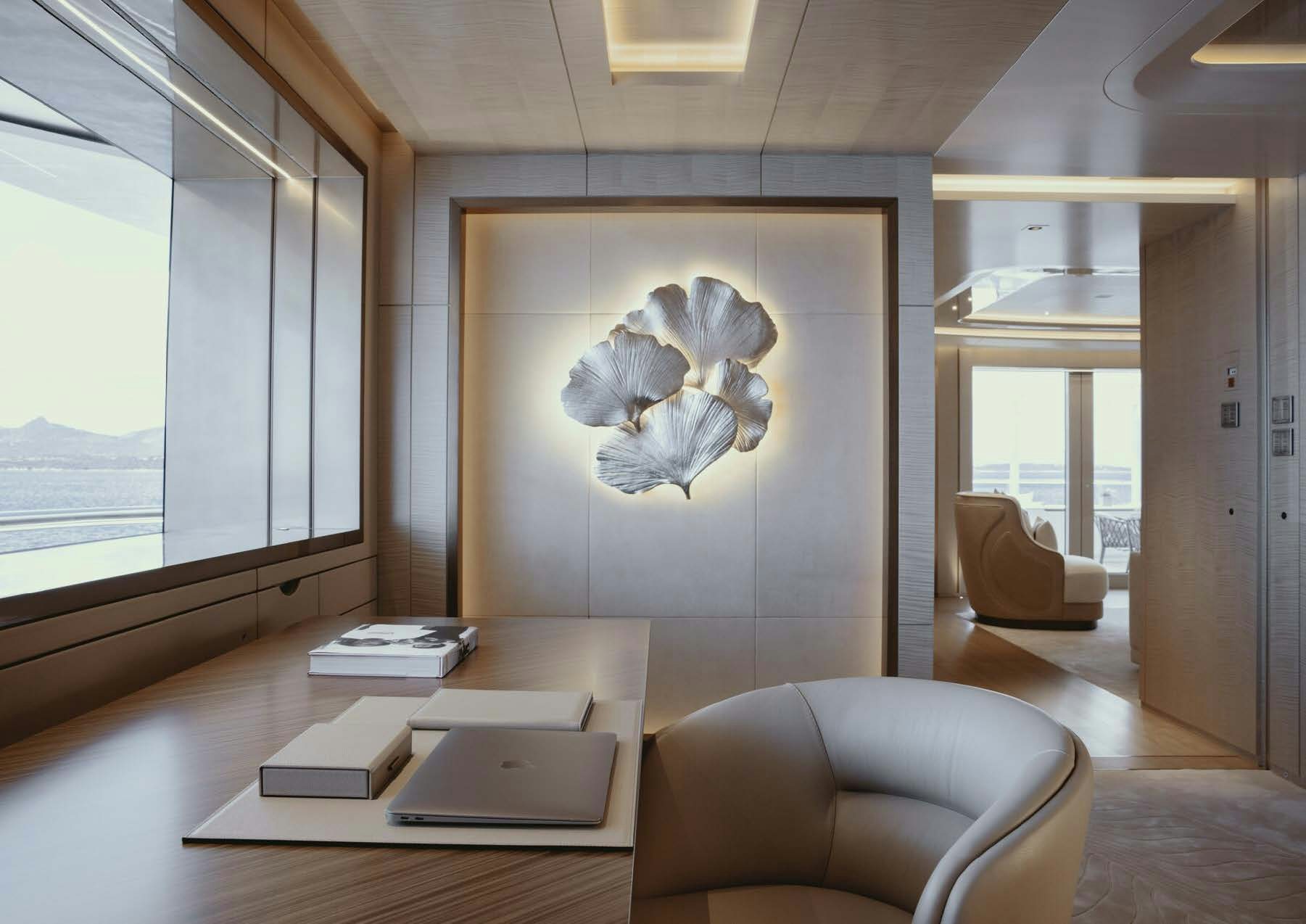 a room with a table chairs and a laptop on a table aboard H3 Yacht for Sale